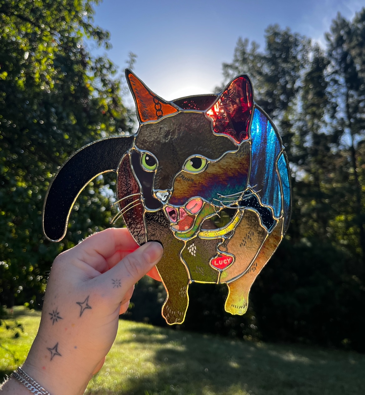 Lucy ❤️ 🐈⬛ love the personality of this baby! So honored to be entrusted with these portraits, especially a memorial one… this design was based on a photo the customer loved (swipe to see), and I’m so glad we could do her justice. I was a little worried she’d might end up being a little black blob (as all our cats actually are in real life honestly) but we used a variety of blacks and dark colors to give her some depth. ⚫️ @glass.creature of course hand-painted her details, including her little white spot, flower collar, and tag! 🌻 Always, always happy to do these for folks, especially as cat lovers ourselves!