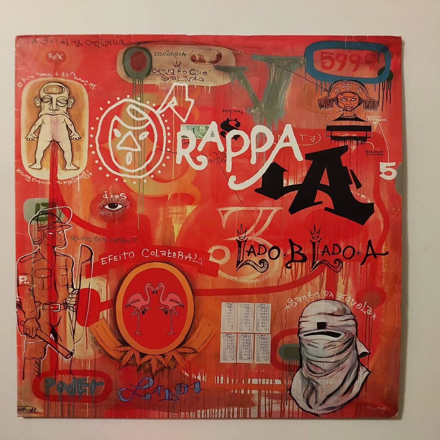 "O ÁLBUM QUE PRECEDEU UMA TRAGÉDIA."
"Lado B Lado A" (1999) é a radiografia mais dura e lírica da violência urbana brasileira, um marco que fundiu rock, rap, reggae e crítica social como nunca.
A capa, uma obra de arte do Doze Green, já dizia tudo: caos, força e contradições. Mas o que poucos sabem é que este LP é o último trabalho da banda antes do ponto de não-retorno: meses após o lançamento, Marcelo Yuka seria baleado, mudando para sempre a história do O Rappa.
Essa cópia aqui é o registro de um momento único. Uma obra de escassez real que você precisa ter na coleção para entender o Brasil dos anos 90.
Apenas uma unidade disponível. (Cópia simples lançada na época e não a dupla que foi relançada anos depois)
#ORappa #LadoBLadoA #MarceloYuka #MinhaAlma #Vinil #DiscoDeVinil #MPB #A VozDoVinil