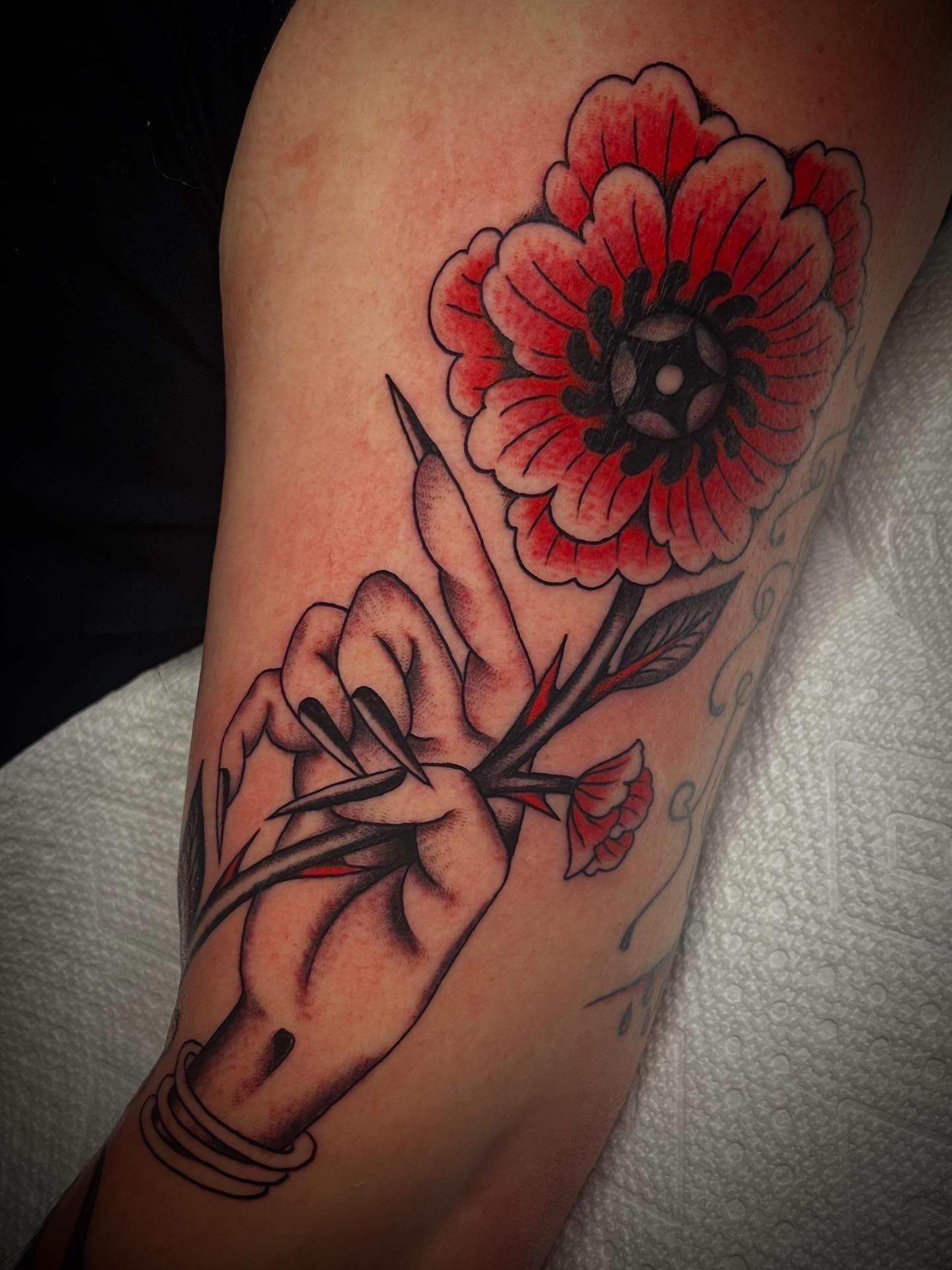 Fresh hand holding a flower (that absorbed a previous tattoo) and a healed strawberry beauty queen by @ellensaintm
