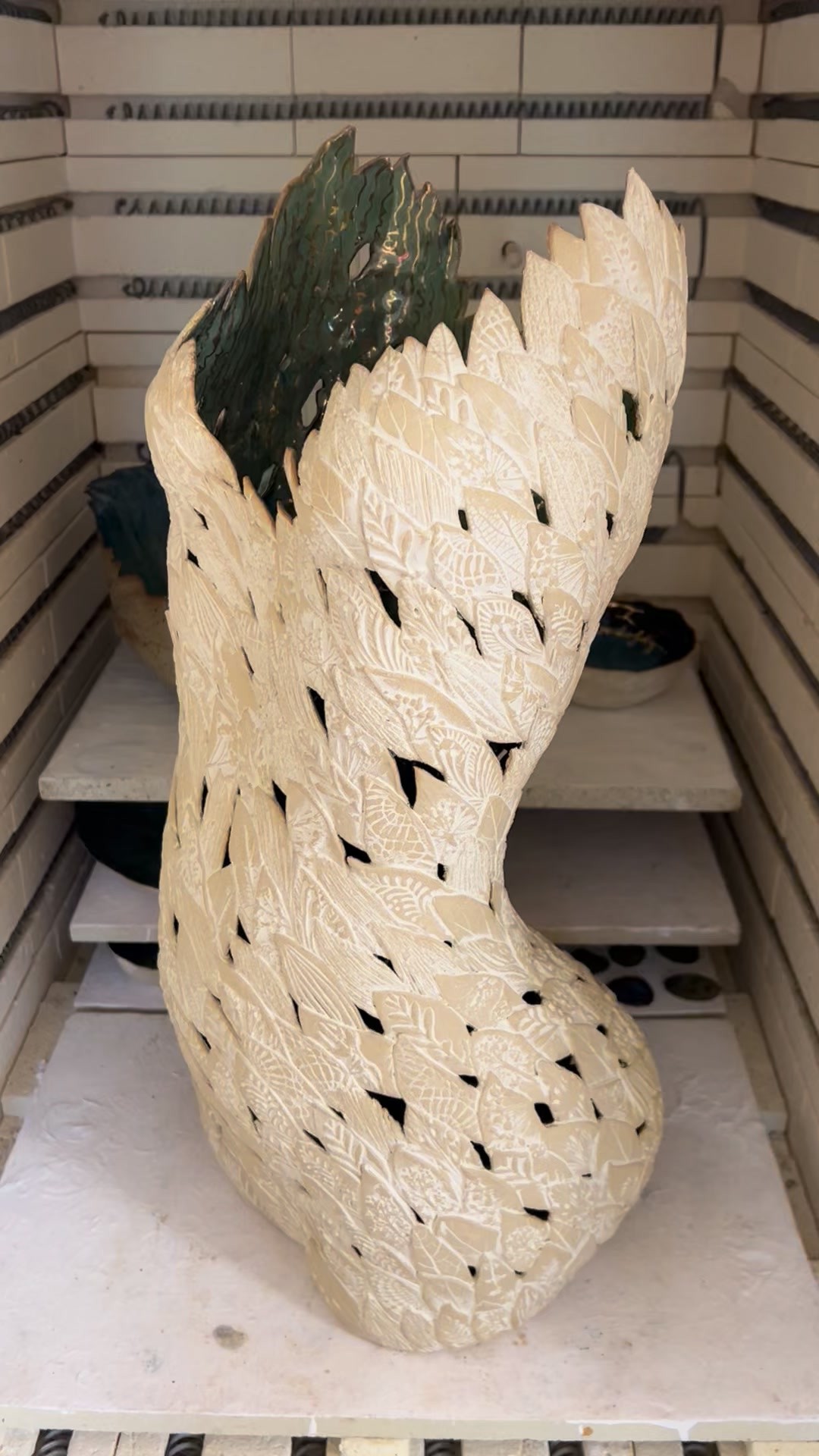 The kiln door opens and my leafy ceramic sculpture is finished… what a journey it’s been and so fun to share it with you.
Because she’s inside the kiln you can’t quite pick up the turquoises and blues in the interior glaze here.But I’m going to get her ready for a proper final twirl tomorrow.
This piece has been built up leaf by leaf, a time consuming but wonderful process which you can find on my profile if you fancy a look.
Now I’m getting a collection ready to release on my website at FayeMayo.com and this piece will be released on there when she’s ready. Or I should say when I’m ready to bid her farewell. Maybe I’ll set up one of those adopt a puppy questionnaires so I’m sure she goes to the right owner😆.
#ceramicstudio #sculpture #ceramicart #golddetail #figurativeartwork