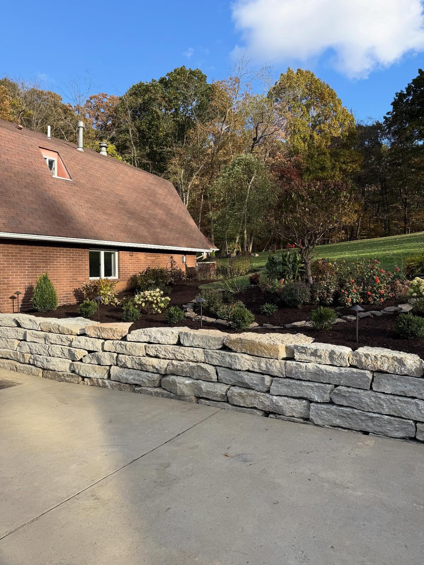 Just completed a breathtaking landscape renovation with natural stone walls, new planting beds and state of the art color changing lights!