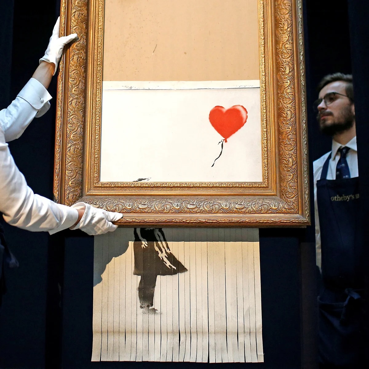 At a Sotheby’s auction, Banksy’s Girl with Balloon sold for over £1 million — only to self-destruct moments later through a shredder hidden inside the frame.
Banksy later revealed he installed the shredder years earlier “in case it was ever put up for auction.” The half-shredded result became a new artwork, ironically doubling in value.
•
A mysterious British street artist, Banksy is renowned for his satirical murals that blend dark humor with striking social and political commentary — transforming public spaces into bold statements that challenge authority, question society, and provoke thought worldwide.
•
Despite global fame, Banksy’s identity remains unknown.
His works appear overnight, often confirmed only through his official Instagram or website.
•
Featured in our Visionary Digest on theboyshostel.com. Visit us to explore more about banksy and other luminaries