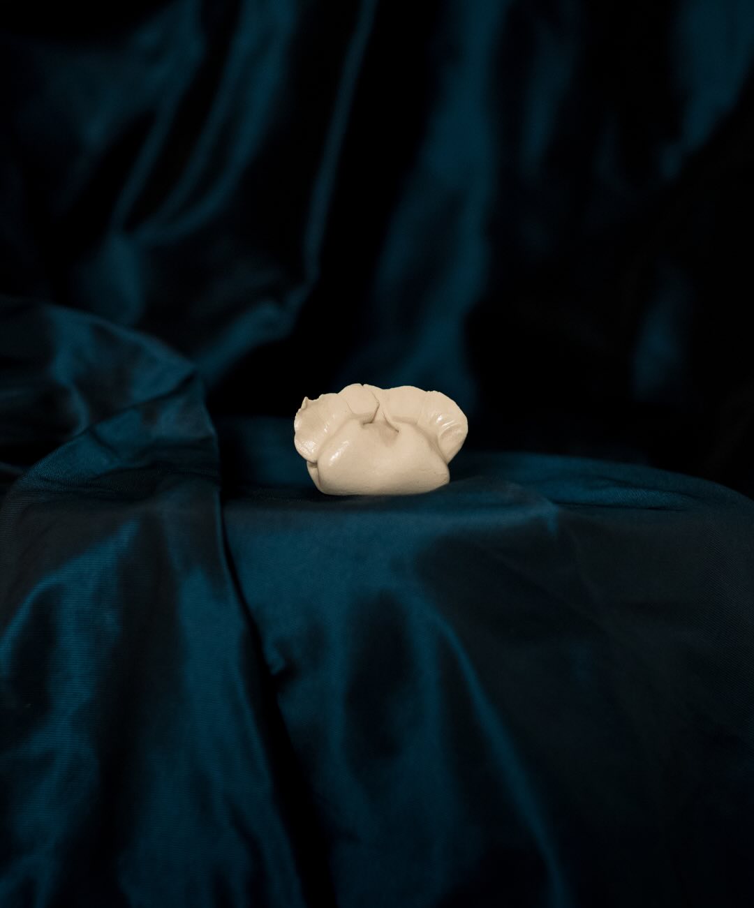 Nostalgia (Dumplings)
By Xu Yang
£800 each
info@vongoetz.uk to enquire
2024-2025
Glazed stoneware
8 x 11.5 cm (various)
19/26 available, all unique sculptures
Xu Yang’s ceramic dumpling sculptures playfully blur the boundaries between art, craft, and everyday ritual.
Each hand-formed dumpling captures a moment of tenderness and humour. These sumptuous little sculptures are a homage to domestic gestures of care, repetition, and cultural memory.
Glazed with delicate translucency, their surfaces hold the quiet intimacy of touch: fingerprints, folds, and the soft suggestion of filling beneath the skin.
These works transform a humble, familiar form into an object of contemplation. Whether gathered in groups or displayed singly, they invite a meditation on nourishment, belonging, and the shared language of food, family, and community.
As Xu recently said;
“In something as intimate as the fingerprints of my mother on a sealed dumpling, I see an entire family and community. In something as delicate as the blue petals of a forget-me-not, I see the precariousness of time. And in something as enduring as gold, I see the power of legacy”.
@_xu.yang_