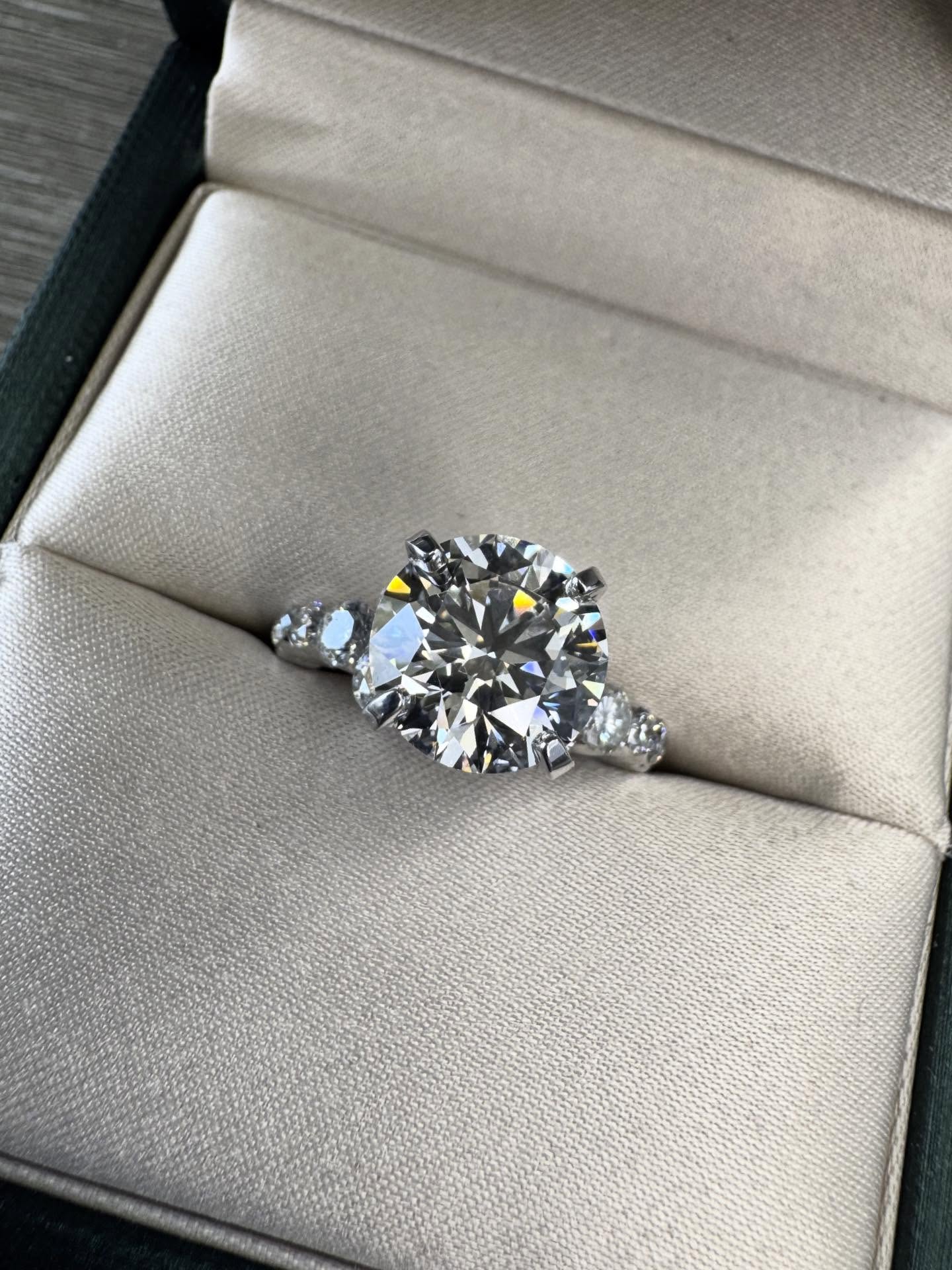 A vision brought to life. We crafted this stunning ring featuring a dazzling 3.26-carat round diamond at its heart, complemented by an additional half-carat of natural diamond accents, all set in polished 18k white gold. This is the art of custom jewelry. What can we create for you!