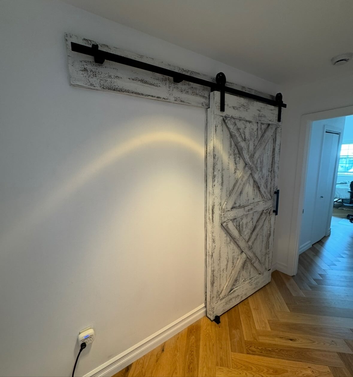 Mia and Kam moved into their new home on Monument Square in Charlestown and they wanted to save space by adding a barn door to the hall bathroom. Both the ability to not have a swinging hinged door in the way and also some added aesthetics were the main drivers behind this but the issue became style and quality. They had started out with a kit door from Wayfair and, well, you can’t customize cookie cutter fake stuff to fit into your nice Boston-area apartment!
Mia wanted a rustic, stressed-look with a specific look and feel that would pop in the space and because of its being thick and sturdy and made from aged pine, and with a wider and taller design, PRIVACY would be provided. This is something the flimsy online or home center “door” cannot provide at all! Our thicker, real wood doors also dampen sound, which was needed here.
The Barndoorist crafted a 2-1/2”+ thick door using aged pine that is over 150 years old, creating the double-X pattern Mia wanted on both the front and back, and despite the apartment having metal studs inside the walls, it is all secured with a ledger beam we crafted and fastened over the entryway.
If you want real, hand-crafted, locally made, and artisan workmanship with innovative US-made hardware that is actually created for customization in New England homes and businesses, please consider us instead of ‘just buying some door’ from the other guys.
#northofboston #ipswichma #marbleheadma #salemma #essexma #essexcountyma #capeannhome #northshoreboston #capeannma #rowleyma #newburyport #nbpt #newburyportma #amesburyma #farmhouse #beverlyma #manchesterbythesea #gloucesterma #barndoors #bostonbuilders #reclaimed #reclaimedmaterials #reclaimedmetal #art #localartist #artisan #antiquedoors #cambridgemass #boston #charlestown