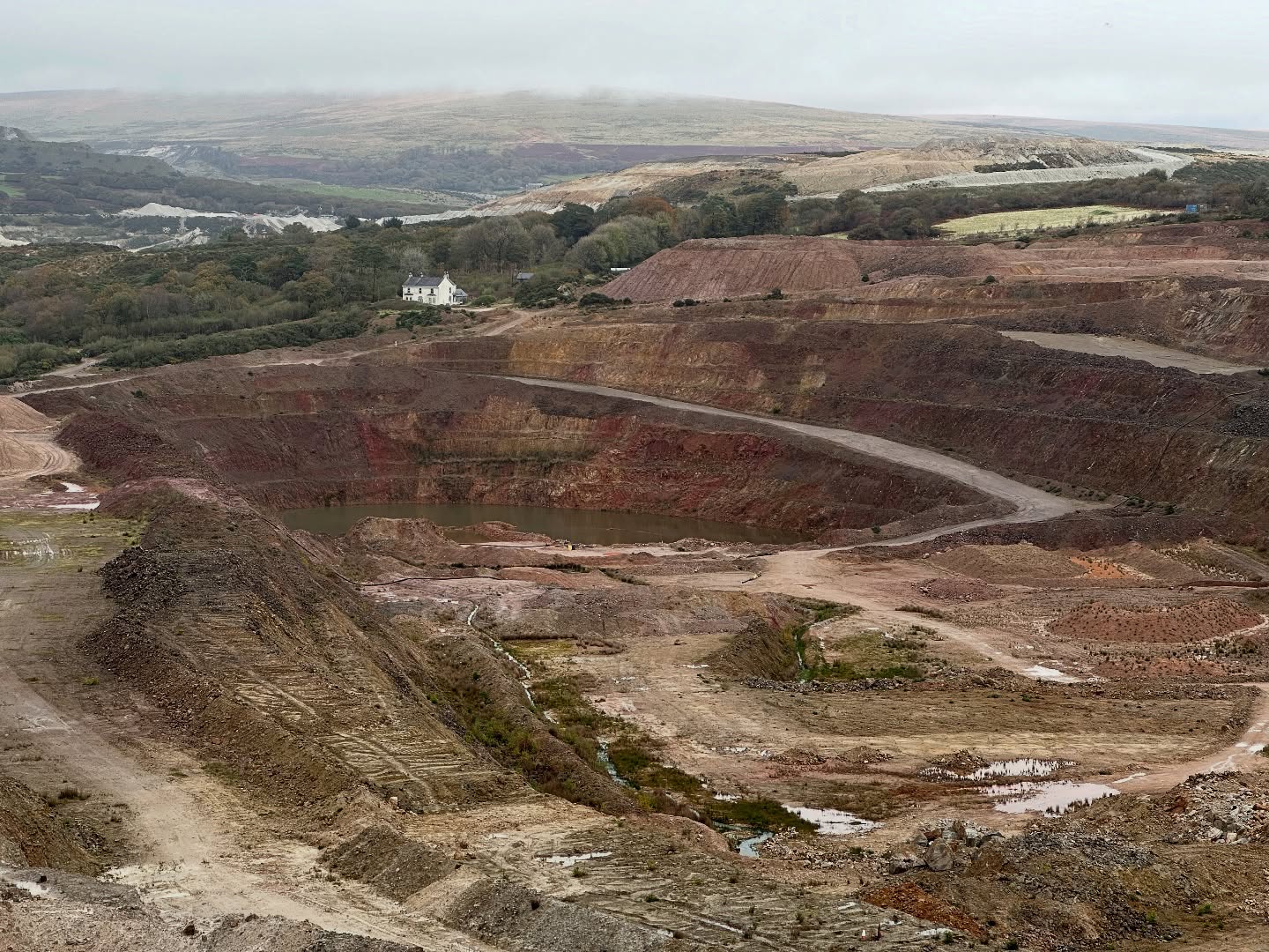 Last week I visited Hemerdon / Drakelands Mine near Plymouth.
This is my first visit in 10 years, so I was excited to see how the site has changed.
Hemerdon is a tungsten/tin deposit situated in a large granite dyke hosted by Upper Devonian slates on the southwest margin of the Dartmoor Granite.
It is a sheeted vein complex - a series of closely spaced veins composed of mainly quartz, with wolframite and cassiterite. It’s similar to Cligga Head and St Michael’s Mount.
It is associated with a style of hydrothermal alteration called Greisen, resulting in mineral assemblages of quartz+mica±topaz which formed due to the reaction between cooling granite and hot fluids rich in F, B and Li.
Tungsten, designated a critical metal by the UK Government, is essential for things like communication infrastructure, automotive industry, and aerospace sector. It is also has military applications, for strengthening steel and armour-piercing projectiles.
Tungsten West who operate the site are working towards going into production in the second half of 2026.
Hemerdon is the 2nd largest tungsten deposit in the world, and if the mine goes into production it would make the UK the 3rd largest producer.
Along with South Crofty, Hemerdon offers a real opportunity to bring metal mining back to the region. Not only will this be an economic boost, but it will have a positive impact on local society.
Mining is an important part of our culture and heritage, and a return of metal mining will make this last 27 years a blip in its 4,500 year history, rather than an end.
It’s really exciting, and I wish Tungsten West all the best for the future.
A huge thank you to Tungsten West, especially Marica Lyndon, Matt Tonkins, Damian Andrews, and the other staff who showed us around. Thank you also to the RGSC for organising the event.
#tin #tungsten #wolframite #greisen #mineralisation #granite #hemerdon #tungstenwest #devon #geology #geologyrocks #geolife #geologist #geologistsofinstagram #learninggeology #geoadventure #exploregeology #geologicalwonders #cornishmining #geologyfieldtrip #geologylife #drakelands #tungstenmine #criticalmetals #ukmining #mininglife #miningindustry #mininguk