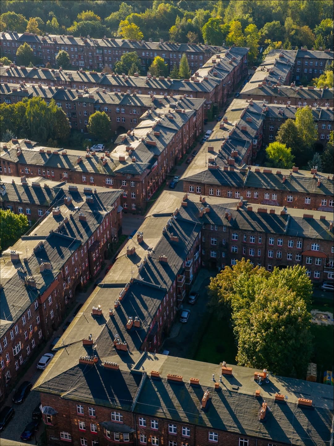 🏗️Nikiszowiec: A Living Memory of the Industrial Era
Pics @silesiadrone_story #weloveexperiences
To understand Katowice’s roots, head to Nikiszowiec, about 10 minutes from the city center. Built in the early 1900s for coal miners and their families, this district is a masterpiece of industrial urban planning. Rows of red-brick buildings, cobbled streets, and inner courtyards create a sense of both history and community that still thrives today.
While it once symbolized the working-class life of the Silesian miners, Nikiszowiec has evolved into one of Katowice’s most atmospheric neighborhoods. Its former workers’ homes now house art galleries, vintage shops, and cozy cafés, where you can try traditional Silesian pastries.
On weekends, the district often hosts craft fairs and cultural events, blending nostalgia with creativity.