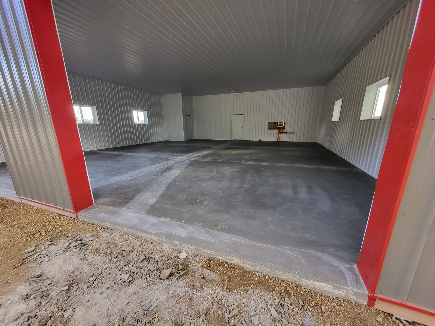 Smooth finish inside, clean grade outside 💪 Concrete floor and gravel driveway complete for this great customer! #LimitlessStructures #ConcreteWork #DrivewayPrep #BarnBuilder