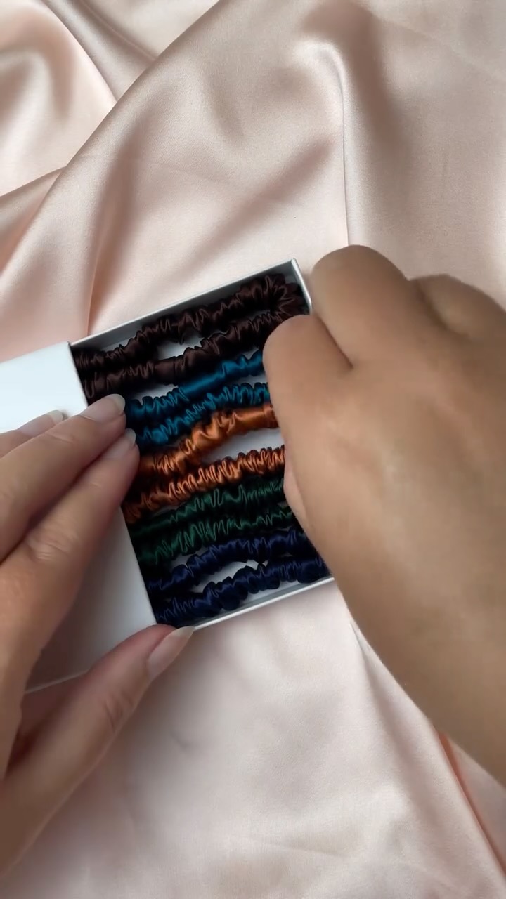 I had an order with some of these colours recently and couldn’t resist putting together a little silk hair elastic gift box with similar vibes.
All my silk hair elastics have a strong elastic and a hand stitched finish and best of all? You can choose your colours in this gift box set! No buying a ready made colour combination where you only like half the colours
Video description- Jo slides open a white gift box to reveal five silk hair elastics in deep brown, teal blue, copper, deep green and navy blue with audio saying “it was official. A new season had begun. After all seasons change, so do cities. People come into your life
