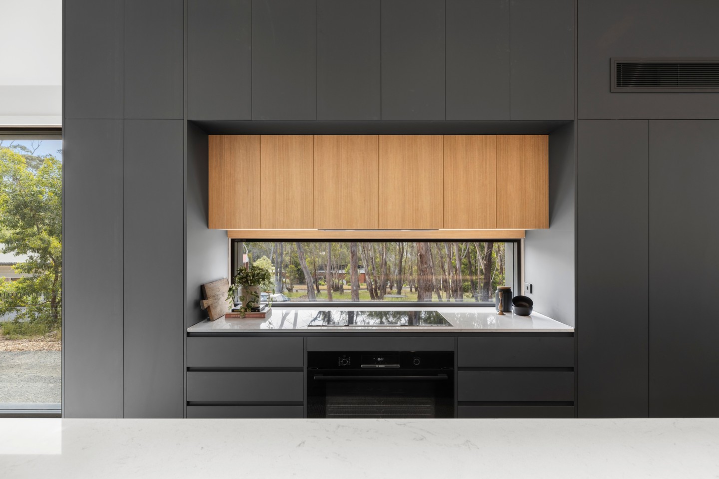 The warm timber cabinetry creates a clean contrast against the dark joinery, framing the landscape beyond the bench.
Design by @bradhooperarchitect
.
.
.
.
.
#buildtrend #buildtrendhomes #masterbuilder #customhomes #macedonrangesbuilder #kitcheninspo #australianarchitecture #interiordesignmelbourne #kitchenwindow #kitchendesignideas #customjoinery #benchtopdesign #windowtothetrees #architecturevictoria #inductioncooktop