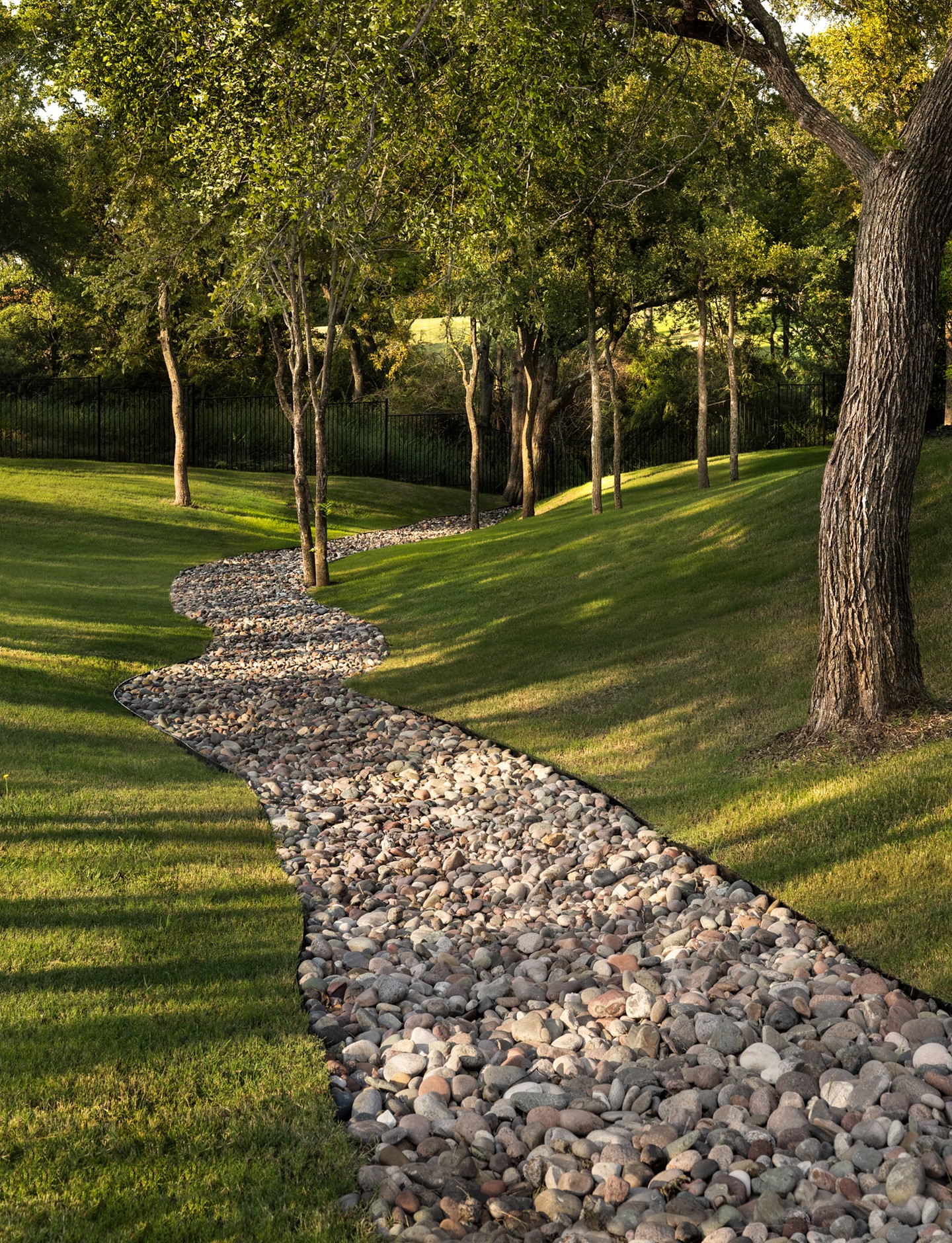Design That Moves Like Nature Itself! 🌿
A well-designed landscape doesn’t just look serene. It works in harmony with nature.
This dry creek bed is more than a graceful visual feature; it’s a living solution for managing rainfall and erosion while maintaining balance with the surrounding oaks and rolling terrain.
By blending natural stone textures, organic curves, and native plantings, our design transforms practical drainage into a sculptural element of calm. The result? A space that feels effortless, where every rainstorm becomes part of the landscape’s rhythm, not its disruption.
That’s the essence of holistic luxury living: beauty, purpose, and peace of mind intertwined.
Photography: @jeniferbakerstudio
Book a Discovery Call to transform your landscape into a living work of art. 📞