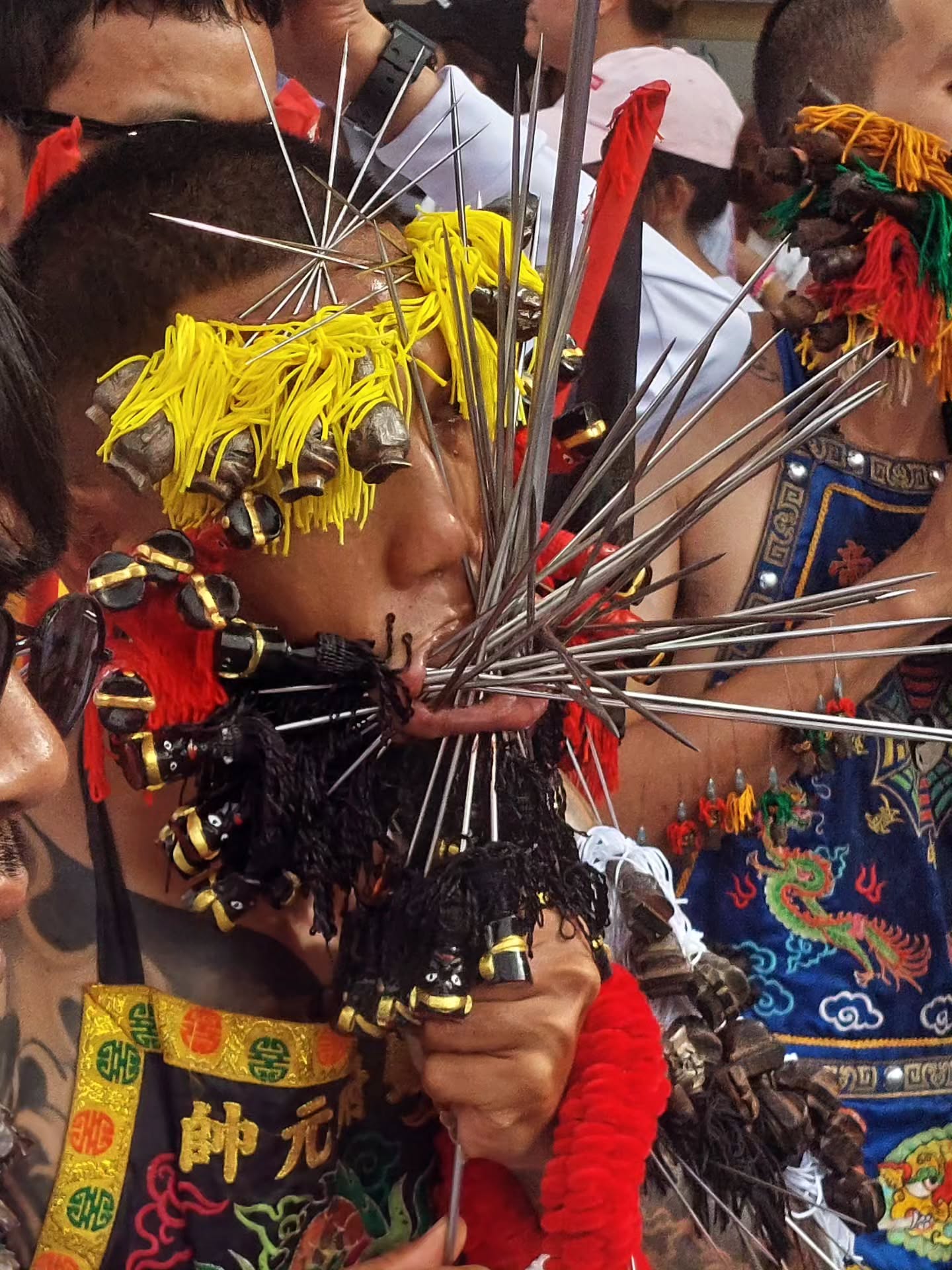 Dadurch, dass wir durch das anhaltende Regenwetter auf Ko Lanta 2 Tage früher nach Phuket gekommen sind, sind wir durch Zufall in den Höhepunkt des "Vegetarien Festival" hineingeschlittert. Dieses Fest (auf Thai: Tesagan Gin Jay) ist eines der spektakulärsten und spirituellsten Feste inThailand - und Phuket ist der bekannteste Ort im ganzen Land dafür. Das Fest stammt ursprünglich aus der chinesisch-thailändischen Gemeinschaft und ist eine Zeit der körperlichen und spirituellen
Reinigung. Die Teilnehmer halten strenge vegetarische oder vegane Diät, verzichten auf Alkohol, Sex und bestimmte Gewürze (z. B. Knoblauch, Zwiebeln) - um Körper, Geist und Seele zu reinigen.
Das bekannteste sind die spirituellen Trance-Zeremonien.
Die "Ma Song" (spirituelle Medien) stechen sich mit Dolchen, Speeren oder anderen Gegenständen durch Wangen oder Körper, als Opfergabe und Zeichen ihrer göttlichen Besessenheit. Das sieht drastisch aus, wird aber in spirituellem Kontext gesehen - Gewalt oder Schmerz stehen dabei nicht im Vordergrund.
Auch werden Feuerläufe über glühende Kohlen durchgeführt, die als Symbol für Reinheit, Mut und spirituelle Stärke gelten. (nächster Post).
Das waren für uns, die wir aus einer ganz anderen Kultur kommen, echt krasse Eindrücke.