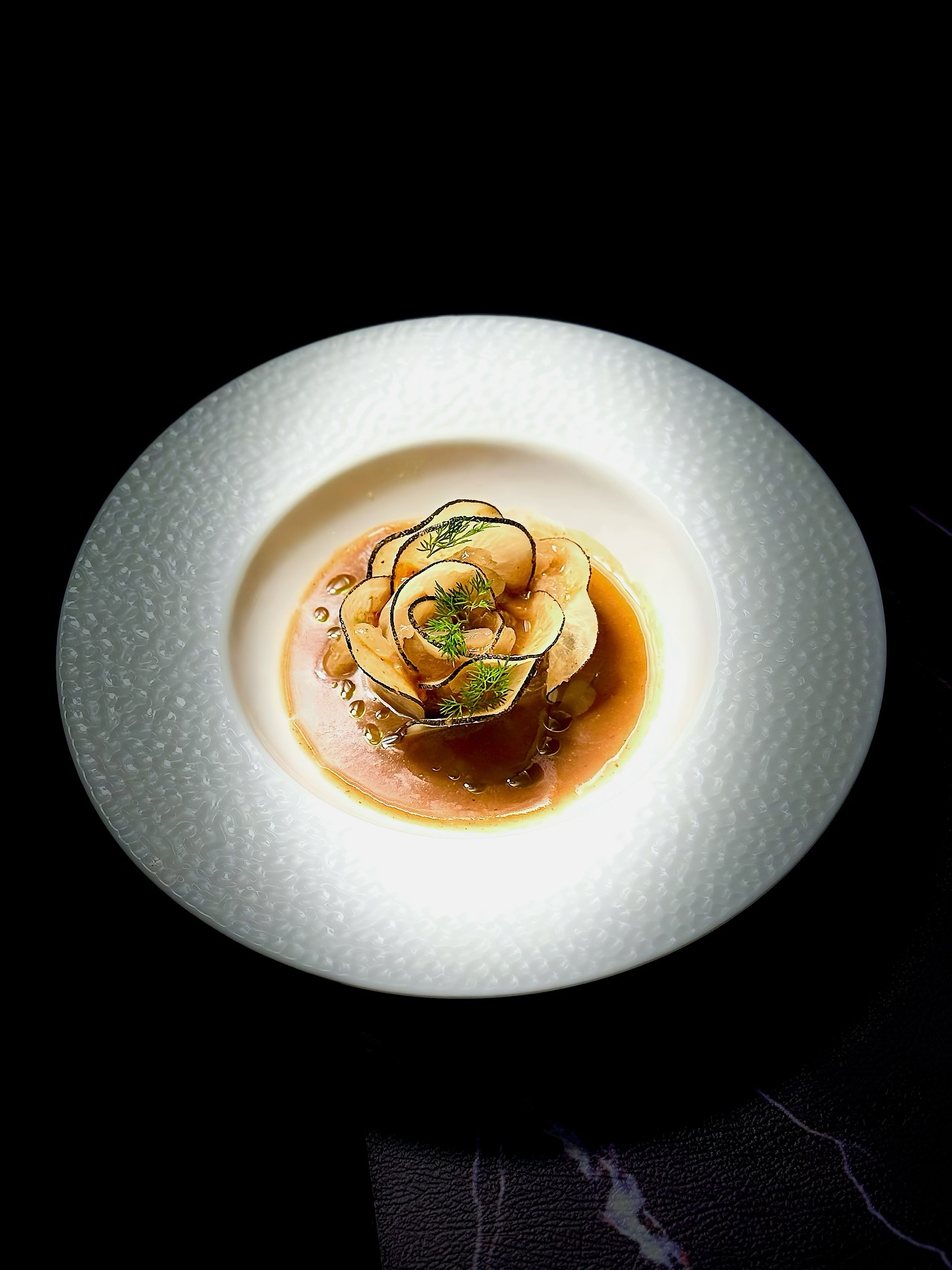 Menu du Soir ❄️
【Éclat de Givre | 霜华初映】
🥢 Radis noir, saumon mariné & sauce aigre-douce à l’aubépine et à la prune noire (wumei)
Ce plat froid se compose de fines tranches de radis noir, accompagnées d’un saumon mariné et d’une sauce aigre-douce à base d’aubépine et de prune noire 🍶.
Le radis noir, croquant et légèrement piquant, s’harmonise avec la sauce acidulée et rafraîchissante, qui stimule l’appétit 🌿.
Entre Lidong (début de l’hiver) et Daxue (grande neige) ❄️, le climat se refroidit et le corps tend à accumuler les graisses et la chaleur interne.
L’aubépine favorise la digestion 🍎 et dissipe les stagnations, tandis que la prune noire apaise et tonifie le système digestif 🍑. Leur association équilibre le corps durant la saison froide 🧘♀️.
La sauce s’inspire de la tradition culinaire Huaiyang, l’un des quatre grands styles classiques de la cuisine chinoise 🇨🇳, réputée pour la finesse du travail du couteau, la maîtrise des cuissons et l’équilibre délicat des saveurs naturelles 🍽️.
🥢 黑萝卜薄片·山楂乌梅汁·三文鱼
这道冷菜以黑萝卜薄片为主,搭配山楂乌梅汁与三文鱼 🍣。
黑萝卜辛香爽脆,佐以酸甜生津的山楂乌梅汁,能够醒胃开食 🌿。
立冬到大雪节气间 ❄️,气候转寒,人体阳气内敛,易生滞气与食积。
山楂助消化、行气化滞 🍎,乌梅收敛生津、调和脾胃 🍑,二者相配,既养生又添味 🧘♀️。
酱汁的灵感来自淮扬菜传统的酸甜调味 🍶,以清雅、和谐、讲究本味著称。
刀工精细,火候精准,滋味平衡,是冬季餐桌上的一抹清新与温润。
📒 Réservation: www.bistrowu.com
#aix #aixmaville #aixenprovence #aixenpce #aixmarseille #HuaiyangCuisine #CuisineChinoise #Gastronomie #FusionFood #WinterMenu #HealthyEating #InspirationAsiatique #RadisNoir #SaumonMariné #SaveursÉquilibrées #artculinaire #淮扬菜 #中国料理 #冬季限定 #养生美食 #红白平衡 #酸甜滋味 #黑萝卜 #山楂乌梅 #中式冷菜 #冬日菜单 #治愈系美食