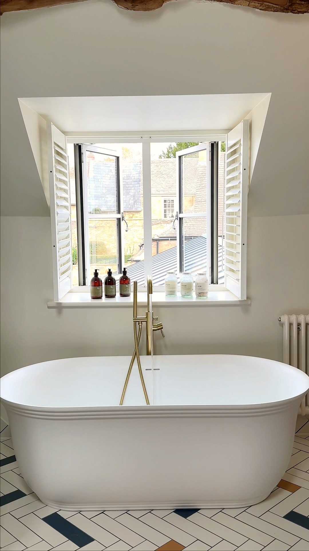 A quiet spot to pause and unwind.
Beneath the window, a freestanding bath looks out over Broadway’s oolitic limestone buildings - a moment of calm in the Luxe King Room.