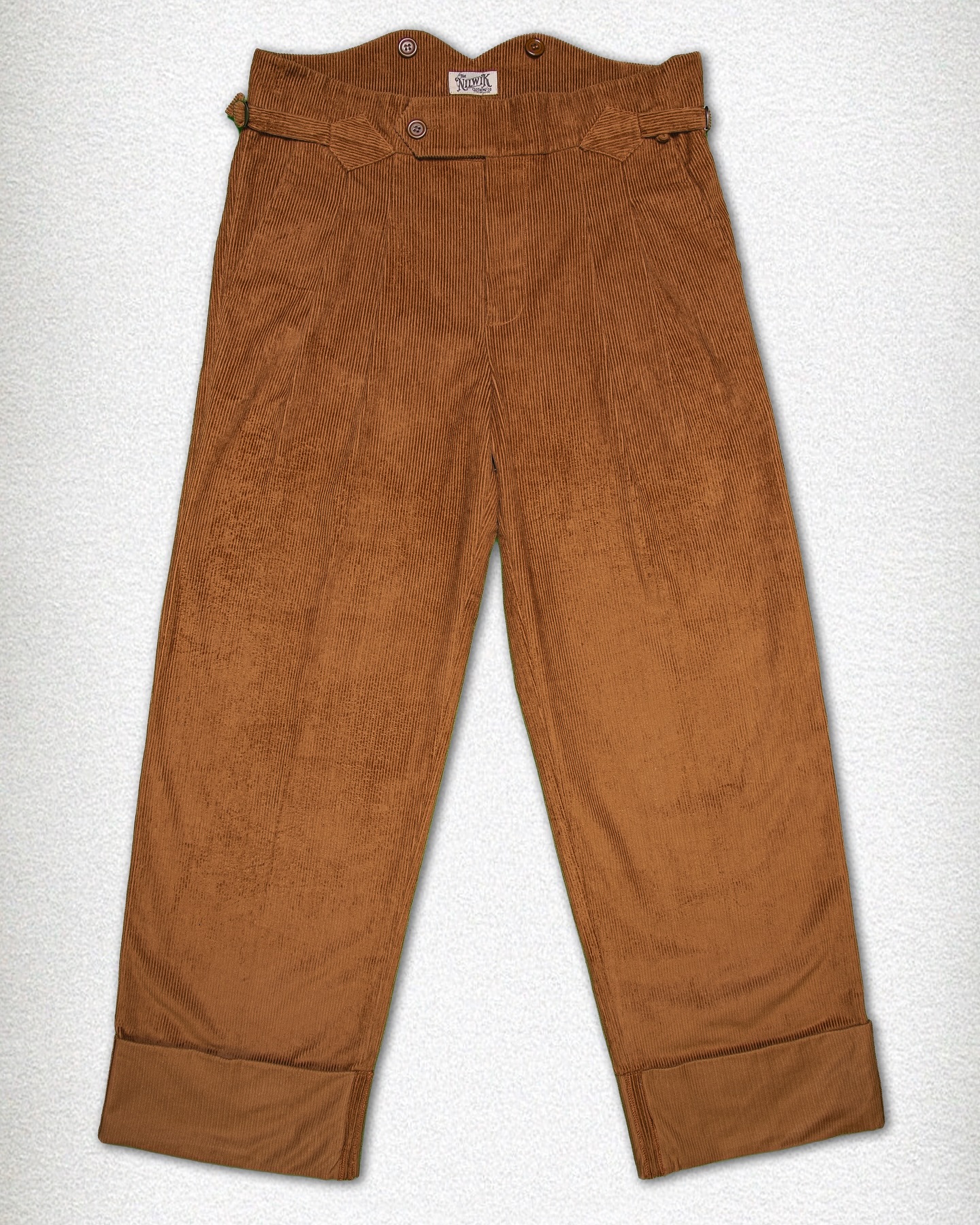 Today we bring you The Moorford.
Corduroy Trousers with Fishtail Back & Buckle Adjusters
Rugged, practical, and full of character — The Moorford pays tribute to the working-class grit of days gone by. Made from heavy-duty corduroy, these wide-leg trousers are built for both style and substance.
The signature fishtail waistband rises high at the back and features interior buttons for braces, just like they used to. Side buckles allow for easy size adjustment, while the generous cut and high turn-ups add a timeless, hardwearing edge.
Available in jet black for a sharp, no-nonsense look, and in rich cognac brown for those who appreciate warmth and texture. The Moorford pairs best with sturdy boots, a tough shirt, and the quiet confidence of someone who knows his roots.