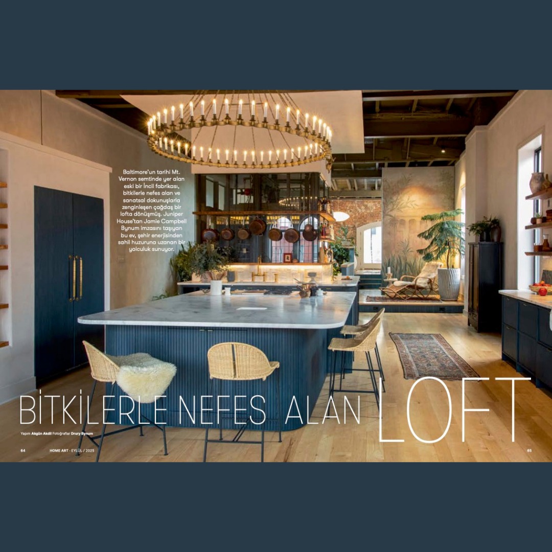 How cool is this? Our #franklinstproject was just featured in Turkish magazine @homeart 🎉 The headline translates to 'A Loft That Breathes with Plants' & YES it does! Our collab with @hiltoncarter gave this space all the incredible greenery it wanted & needed! Thanks @homeart for sharing this special project. Article translation: 'In Baltimore’s Franklin Street, an 1860s townhouse—known locally as the “Bible House”—has been reimagined by Juniper House Studio into a soulful loft that marries history, city energy, and coastal calm. Once an empty industrial shell, the space now spans nearly 2,000 square meters of light and character.
Jamie Campbell Bynum, founder and principal of Juniper House Studio, recalls: “With its high ceilings, generous proportions, and original working elevator, the space was both inspiring and challenging. Dividing it naturally into two zones—north for cooking and dining, south for living and gathering—became the foundation of the design. We wanted it to feel expansive yet deeply personal.”
To evoke the serene spirit of the homeowners’ Puerto Rican retreat, lime wash introduced a soft, natural texture. Artist Drury Bynum—Jamie’s husband and creative partner—painted a bespoke wall mural described as “a meditative landscape suggesting distant horizons,” adding a personal, poetic layer to the architecture. Material choices carried the narrative forward: Zellige tiles, handmade ceramics, custom fixtures, and vintage rugs infused warmth and patina. Each piece, curated with intention, contributes to a tactile and lived-in atmosphere—one that celebrates imperfection and artistry.
A standout moment in the home is the living green wall, rising through the stairwell in collaboration with acclaimed plant stylist Hilton Carter.
“That section was once just a flat, empty wall,” says Jamie. “It was calling out for something alive. We opened the skylight to bring in natural light, and suddenly, a vertical garden of 500 plants came to life.” The kitchen represents another meaningful collaboration—custom cabinetry designed with Jim Klausmeyer of Bmore Reclaimed, inspired by the weathered facades of neighboring history.' @bmore_reclaimed @elizabethscollan
