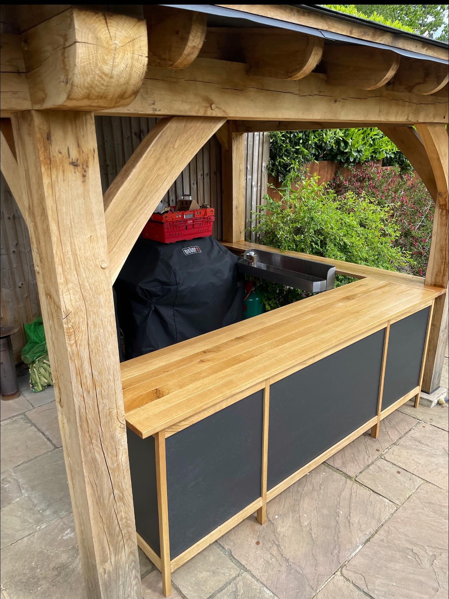 Bespoke oak bar with integrated storage, tailored for summer BBQs. #oak #outdoor #madetomeasure #moderndesigns