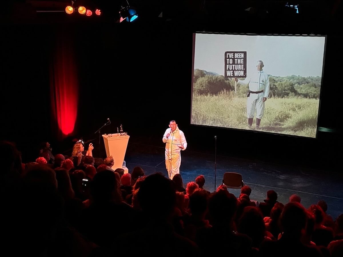 Verliefd worden op de toekomst! Gisteren liet @robhopkins5085 in Theaterbroedplaats @desloot.amsterdam 185 mensen tijdreizen naar de toekomst 🚀 om te verbeelden hoe we dan zouden leven.
Rob liet ons voelen dat verandering niet begint bij angst, maar bij een toekomst die zo levendig, menselijk en hoopgevend is dat we er met groot verlangen naartoe willen groeien. Zijn uitnodiging om weer verliefd te worden op de toekomst is ruimhartig aangenomen, en we gingen allemaal met moed en creatiekracht naar huis. @stichtingsymbio was trots partner van dit inspirerende event #partner