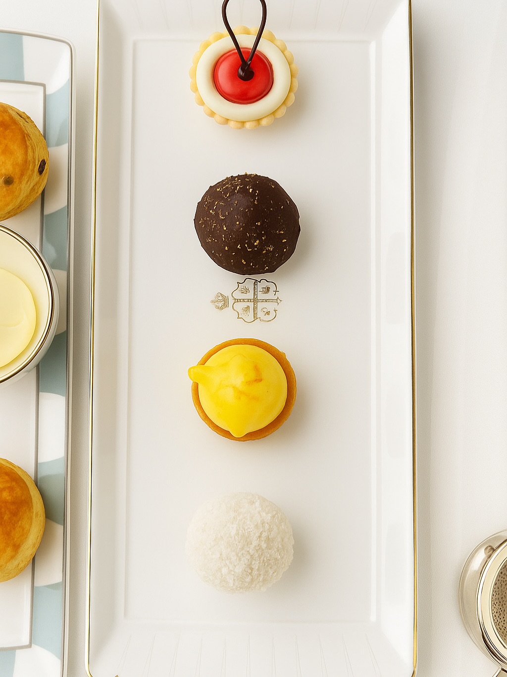 High Tea at Claridge’s: A London Ritual Worth Savoring
There are few London traditions as timeless and as quietly enchanting as afternoon tea at Claridge’s. Tucked into the heart of Mayfair, this iconic hotel has perfected the art of transforming everyday moments into something truly memorable. Stepping into the Foyer & Reading Room feels a bit like walking into a jewelry box: soft light glinting off marble floors, the gentle hum of conversation, and that unmistakable Claridge’s elegance in every detail.
The experience begins with a flute of champagne or a fresh pot of your chosen loose-leaf tea. By the tea, we fell in love with the Claridge’s Blend Fruit Vanilla Tea, a fragrant mix that feels both cozy and indulgent. The menu reads like a love letter to tea culture, with selections ranging from delicate white teas to rich Assam blends. The staff, gracious without being overbearing, will happily guide you to the perfect pairing.
This season’s menu is filled with a subtle Christmas charm. The selection of sandwiches feels like a celebration in itself, from the decadent truffle tart to the turkey and cranberry sandwiches that evoke classic holiday flavours. Even the condiments carry a festive spirit, with spiced jams that pair beautifully with warm bakes and a nod to tradition through a delicate Christmas pudding bite that rounds out the experience.
What makes Claridge’s tea truly special is the atmosphere. It is never rushed, never loud, never fussy. It is simply hours suspended in a cocoon of civility where time seems to stretch, conversations linger, and the clatter of the city feels very far away.
Whether you are marking a milestone or simply indulging in a beautifully slow afternoon, high tea at Claridge’s is London at its most graceful, a must-do ritual for travelers seeking a taste of old-world charm wrapped in contemporary luxury.