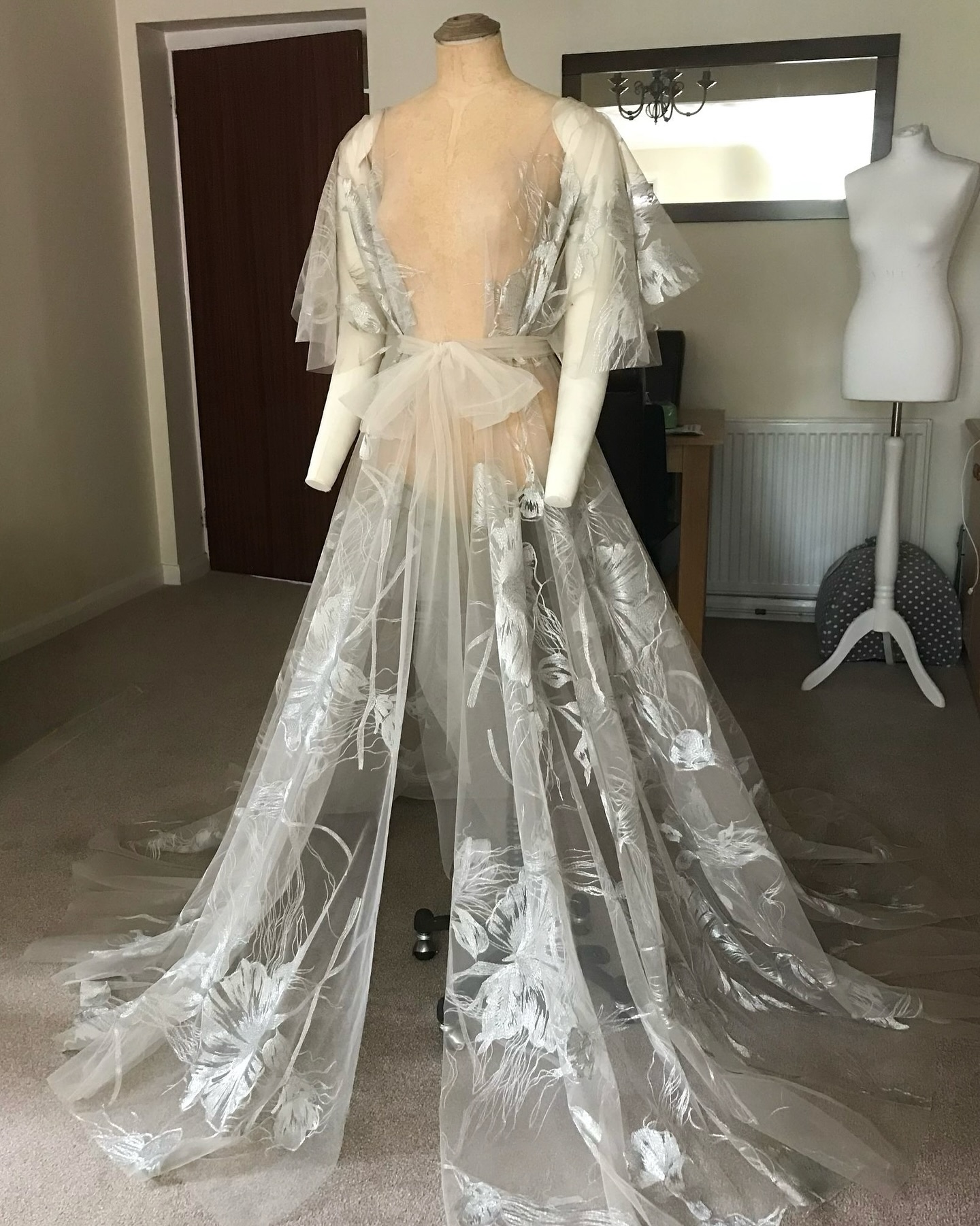 • Celeste •
Capturing this robe in a single frame was no easy feat, but I couldn’t resist sharing this behind-the-scenes moment from when it was finally complete.
Layers of silver metallic embroidery cascade across soft beige tulle, melting seamlessly against the skin. Full, fluttering butterfly sleeves and a sweeping, dramatic train come together to create a truly decadent silhouette…
#EmiahCouture #Emiah_Celeste