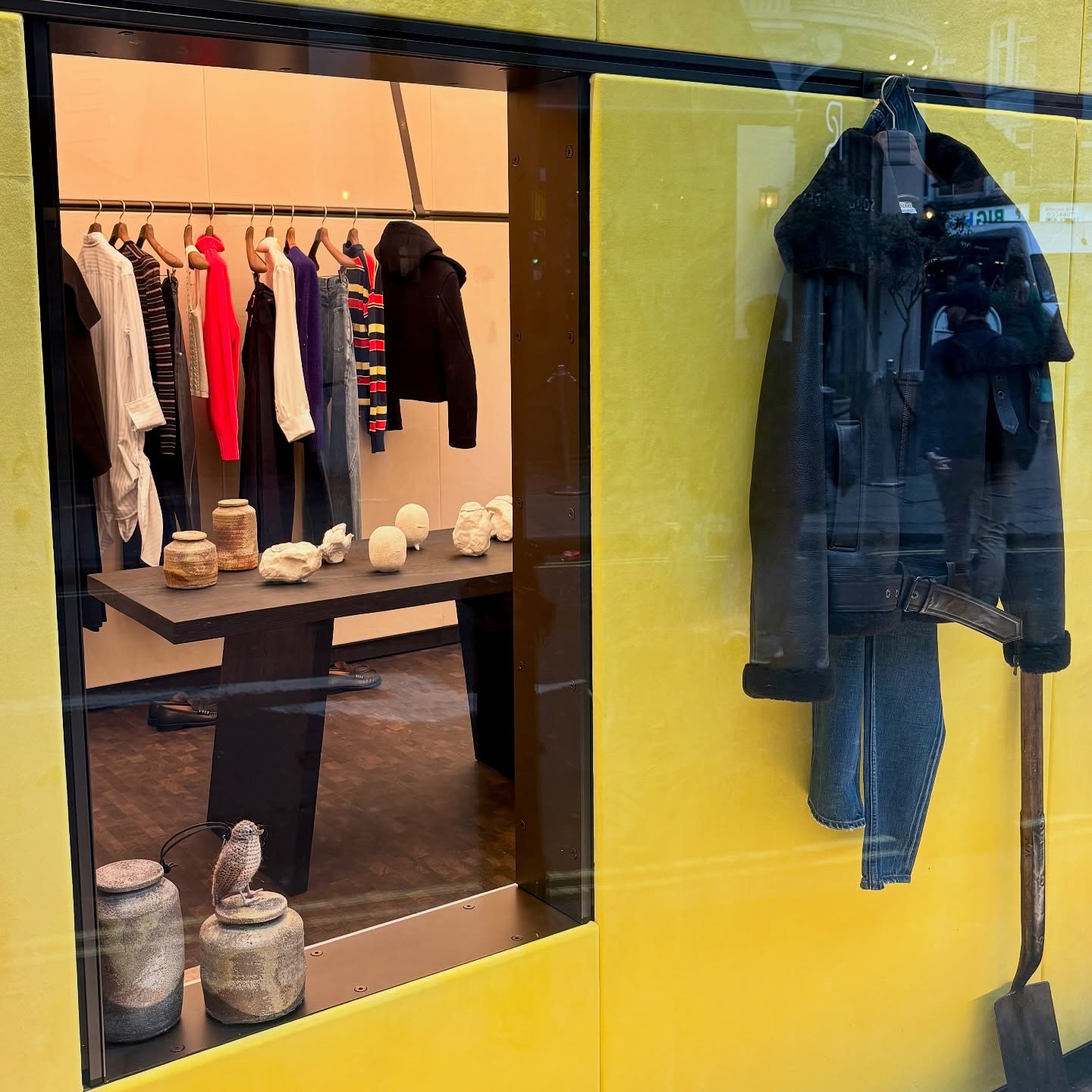 In the heart of Soho, JW Anderson’s flagship isn’t just a fashion store: it has become a modern cabinet of curiosities, where everything feels deeply personal and thoughtfully placed. What feels anonymous at first glance is actually intensely curated by Jonathan Anderson himself, a treasure trove combining clothes, craft, and culinary oddities.
Recently, Anderson has doubled down on his curatorial vision. In the 2025-2026 relaunch, the store leans into a lifestyle concept: not just clothes, but objects of craft, curated oddities, and everyday heirlooms. Think antique gardening tools, Murano glass, Lucie Rie mugs, Shaker-inspired furniture, honey from stately estates, even coffee-scented tea.
The whole space feels Japanese-minimal in spirit: restrained materials, quiet warmth, and a sense of calm intentionality. But unlike a sterile showroom, it’s deeply lived-in: textures feel warm, colours are muted but rich, and every object carries meaning.