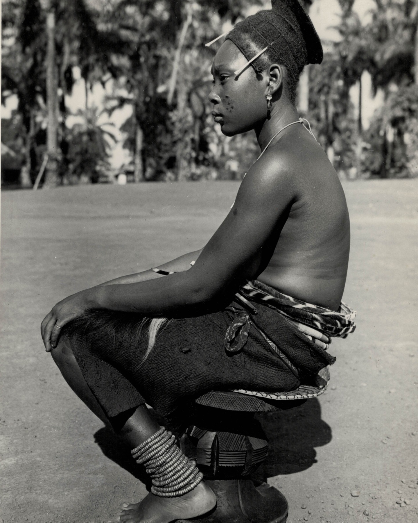 Lieven Storme vintage African photography and tribal art.
Picture of the day #123.
Heart4Darkness offers a collection of over 5,000 original vintage photographs that illuminate the rich cultural history and heritage of the African continent. All photographs have been assessed for authenticity, artistic quality, and condition of preservation and are unmounted or disbound unless explicitly stated otherwise.
Photographer: Goldstein, Henri (1920-2014).
Title: untitled (femme Uélé region).
Date: 1949.
Country: Democratic Republic of the Congo.
Medium: unmounted gelatin silver print.
Size: 24,0 x 17,8 cm.
Condition: very good.
Reference: HGV1115/1.
Provenance: Belgian vintage photograpy dealer.
Extra: typed note with identification in French. Congopresse 22.332/37.
Location: Medje.
Province: Haut-Uele.
In the Uélé, especially in the territory of the Mangbetu, Makere and that of Niangara, one finds, among various forms of indigenous art, curious carved stools. These are reserved for women. Tradition teaches them how this small piece of furniture must be carried. Tradition also teaches them how to sit and how to behave in public. With the legs at a sharp angle, the knees together, the torso straight, the hands placed on the knees, the gaze distant and avoiding eye contact with the interlocutor or passer-by — this is the hieratic, almost ritual posture of the women of these regions. This posture reveals its full beauty when worn with traditional dress: a black skirt made of beaten and dyed bark, an elongated hairstyle decorated with monkey bones, and the lower back protected by the ‘negbe,’ an oval ornament made of banana leaves combined with decorative motifs of great inventiveness.
Consult our website for a biography of the photographer.
#drcongo #uélé #mangbetu #makere #niangara #givepeaceachance #vintageafricanphotography #vintagephotography #arttribal #tribalart #artinbruges #henri_goldstein #henrigoldstein #beautifulpeopleinabadworld #congopresse #inforcongo #medje #hautuele #hautuélé #orientale #provinceorientale #belgiancongo #congobelge