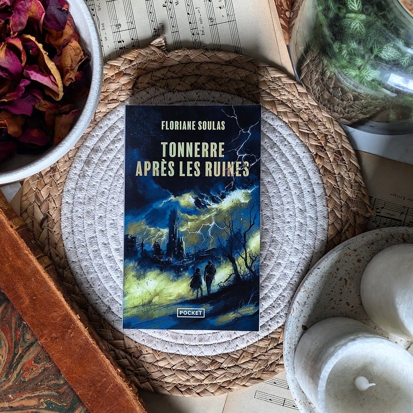 ✨ Le Tonnerre après les ruines - Floriane Soulas ✨
Imaginer un monde ou la faim, la boue et la peur sont partout. Un monde où les villes se referment comme des pièges et où les monstres que l'on traque ne sont pas toujours ceux que l'on croit...
C'est dans cette ambiance de fin du monde que Floriane soulas nous embarque dans le tonnerre après les ruines. Il s'agit ici d'un post-apo assez violent, sale, poisseux, où juste survivre, c’est déjà un acte de résistance.
Tout l'univers nous fonce dessus sans nous laisser respirer et j'ai adoré ça ! Le gros point positif avec tout ça c'est que c'est impossible de lâcher le livre.
On y suit d'ailleurs un duo qui marche incroyablement bien. D'un côté on retrouve une femme dure, Lottie, qui s'avère être une guerrière aguerrie et une soigneuse autodidacte. De l'autre, celle qui l'accompagne, Férale, sans cesse comparé aux monstres à cause de son apparence.
Leur quotidien est millimétré, presque mécanique… jusqu’au jour où un nom de cité surgit : Tonnerre. Et avec lui, des possibles réponses.
Ce roman est très fort pour jouer sur les oppositions : l’extérieur ravagé face aux enclaves protégées, la raison face aux croyances qui prospèrent dans la misère, la liberté contre l’illusion de la sécurité. Ce qui est génial, c'est qu'on sent le World building, qu'il y a de la matière et que clairement on aimerait pas vivre là-bas.
L’ambiance est étouffante, parfois franchement dérangeante... Mais ça fait partie du package post-apo. Les personnages ne sont pas là pour être des héros, il tente simplement de vivre.
Chaque révélation fait grimacer, chaque choix est important et la tension ne lâche véritablement jamais.
Un roman noir, violent et terriblement efficace.
Si vous aimez les récits post-apocalyptiques, celui-ci est fait pour vous.
Le roman est publié chez @pocketimaginaire !
#LeTonnerreAprèsLesRuines #FlorianeSoulas #PostApocalyptique #SFFF #LectureAddictive