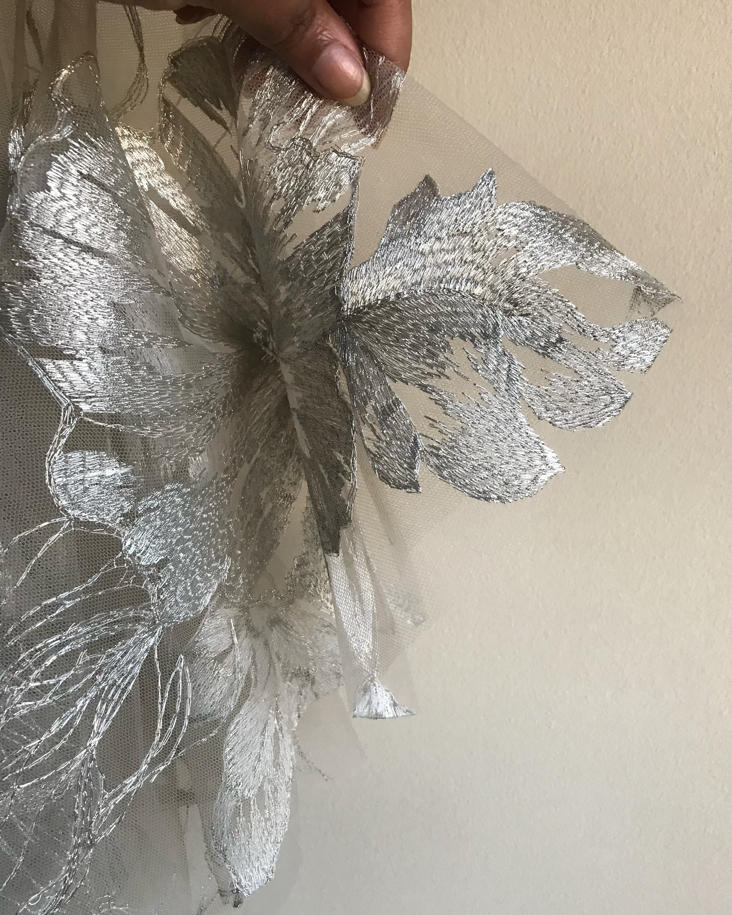 • Celeste •
This embroidery was so delicate that I found myself searching for a way to finish its edges without disturbing its quiet elegance. Tulle may not fray, but the embroidery certainly would and every traditional method felt too heavy, too eye catching which would take away from the design’s soft radiance.
So I began to experiment. One approach was to heat seal the edges, melting the metallic threads just enough to create a neat finish. To my delight, it worked beautifully! This result is an almost invisible edge that lets the embroidery to breathe, uninterrupted and speak for itself.
#EmiahCouture #Emiah_Celeste