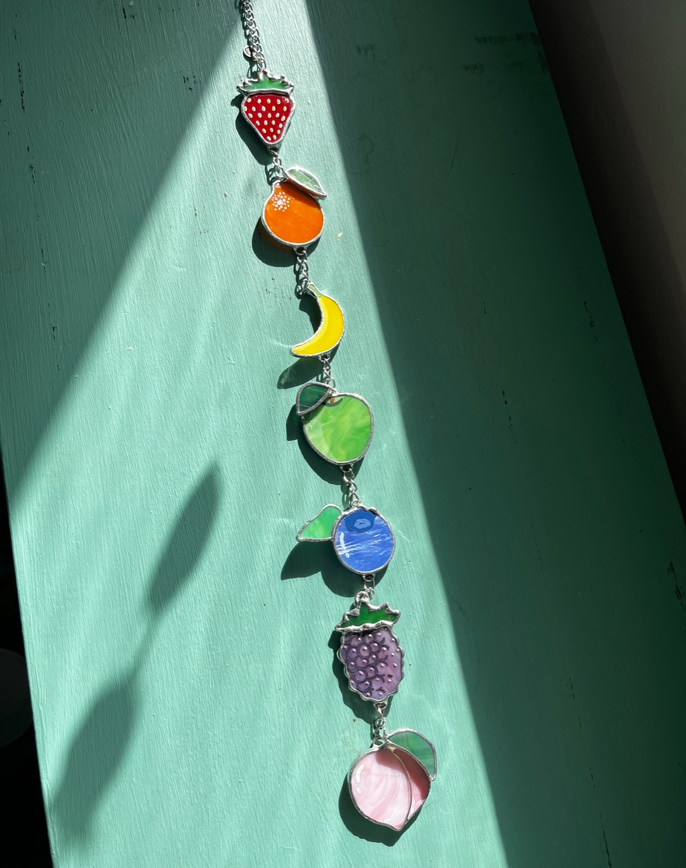 Rainbow fruit chain 🍓🍊🍌🍏🫐💜🍑 the fact that there’s no blackberry emoji is criminal here! These look even better flat on the window with the sun coming through 🥰 a more subtle pride piece for all you sweet little fruits 🏳️🌈