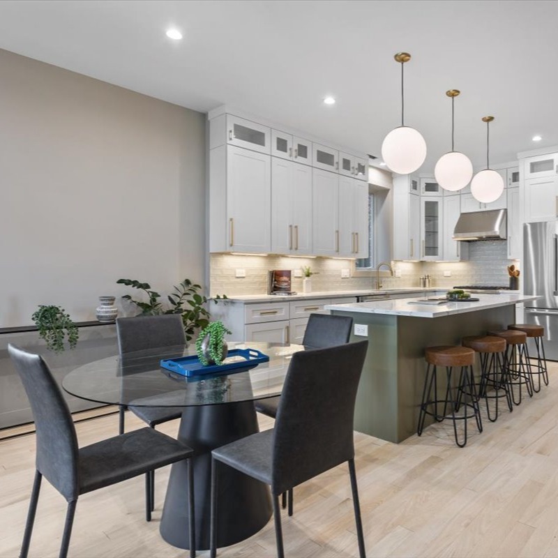 Splashes of greenery complement the hue of the kitchen island, while pops of blue add visual interest throughout the rest of the space. #chicago #chicagorealestate #havenhomestager #chicagohomestaging #stagingworks #stagingsells #staging #homestaging