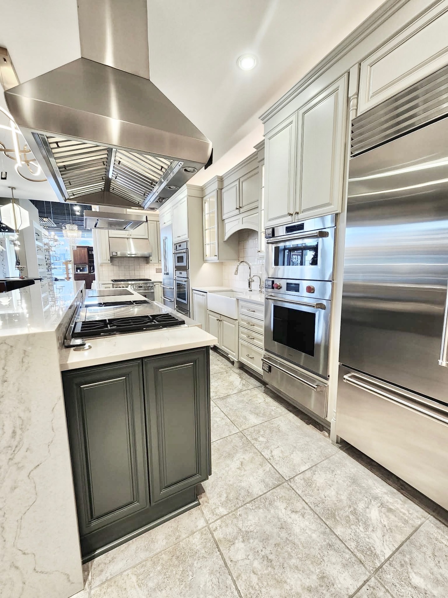We refinished these cabinets at the Ferguson Home showroom, taking them from an aged, yellowed old-world finish to a clean, updated look. The island is painted Sherwin-Williams āFoxhall Greenā, paired with āSymmetryā on the perimeterāperfectly complementing the new countertops, backsplash, and those stunning appliances!