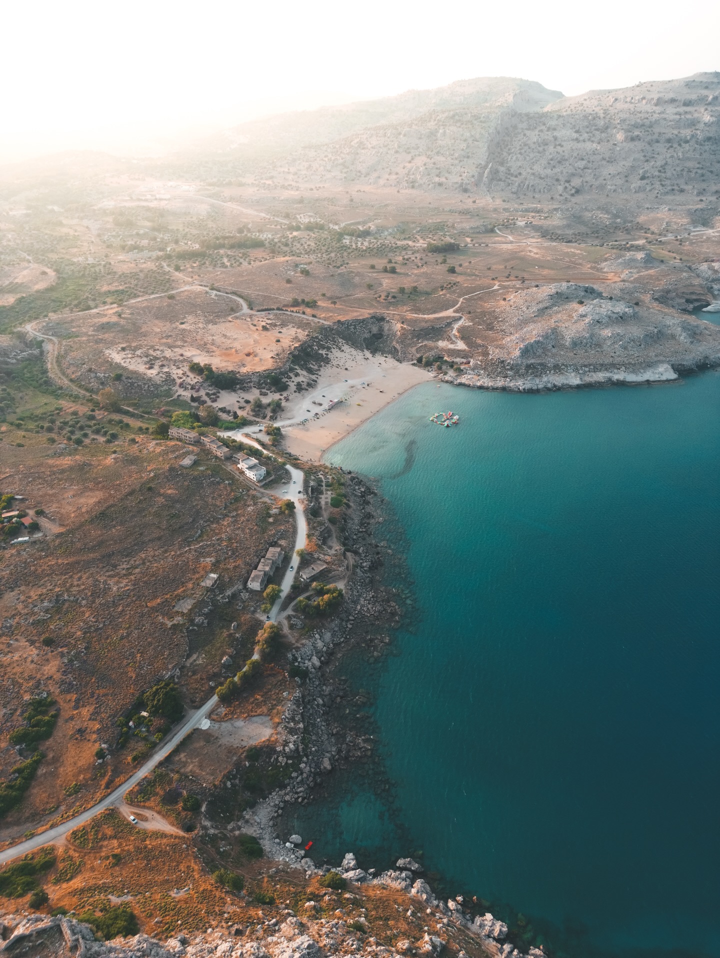 Charaki liegt in einer klar geformten Bucht, eingerahmt von zwei Felszügen, die das Wasser ruhig halten. Die Küstenlinie ist schlicht. Kies, Felsen, offene Flächen. Wenn man sich mit der Kamera bewegt, merkt man schnell, wie sauber sich die Linien ziehen. Links der höhere Hang mit rauer Struktur, rechts die flachere Seite mit breitem Uferstreifen. Das macht es einfach, breite Bilder zu setzen.
Das Wasser wirkt je nach Winkel anders. Von oben deutlich heller, fast schon türkis, unten am Strand dunkler und tiefer. Die Felsen brechen das Licht in klaren Übergängen, was für Kontraste sorgt, ohne dass man viel arrangieren muss. Wenn man die Höhe wechselt, bekommt man sehr direkte geometrische Formen. Die Bucht wird zu einem Halbkreis, die Hügel zu zwei klaren Blöcken, und das Meer zieht eine gerade Linie aus Blau.
Rund um Charaki wird es schnell felsig. Die Hänge sind trocken, wenig Bewuchs, viel Stein. Wer Landschaft fotografiert, bekommt scharfe Kanten, klare Strukturen und wenig Ablenkung. Selbst bei starkem Licht lassen sich Details gut rausziehen, weil die Landschaft wenig Chaos hat. Breite Shots funktionieren genauso gut wie enge Ausschnitte von Felsformationen.
Der Blick von der Burg aus legt die ganze Küste offen. Man sieht, wie die Farben wechseln. Türkis, Dunkelblau, Grau der Felsen, helle Flächen am Ufer. Sehr direkt, sehr klar. Keine komplizierten Muster, nur Landschaft, die sich sauber lesen lässt.
#charaki #rhodos #rhodosgreece #greece #greecetravel #greekislands #landscapephotography #coastline #aerialview #fokusfernweh #mediterranean #travelphotography #islandlandscape #travelgram