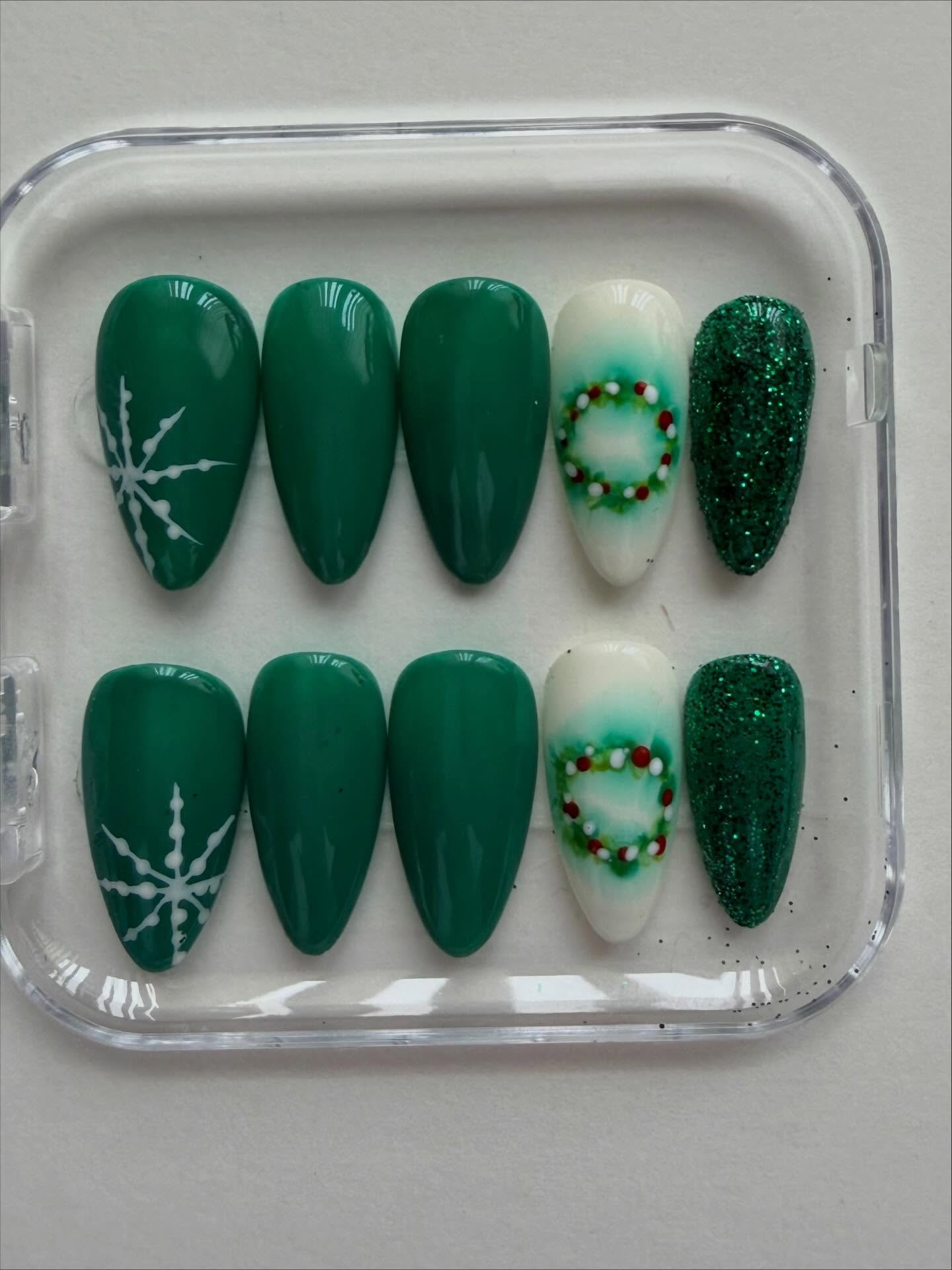 Hand painted green Christmas wreath themed press on nails with snowflake nail art design #nailsnailsnails #christmasnailart #christmas #nailart #handpaintednails #nails #christmasnails