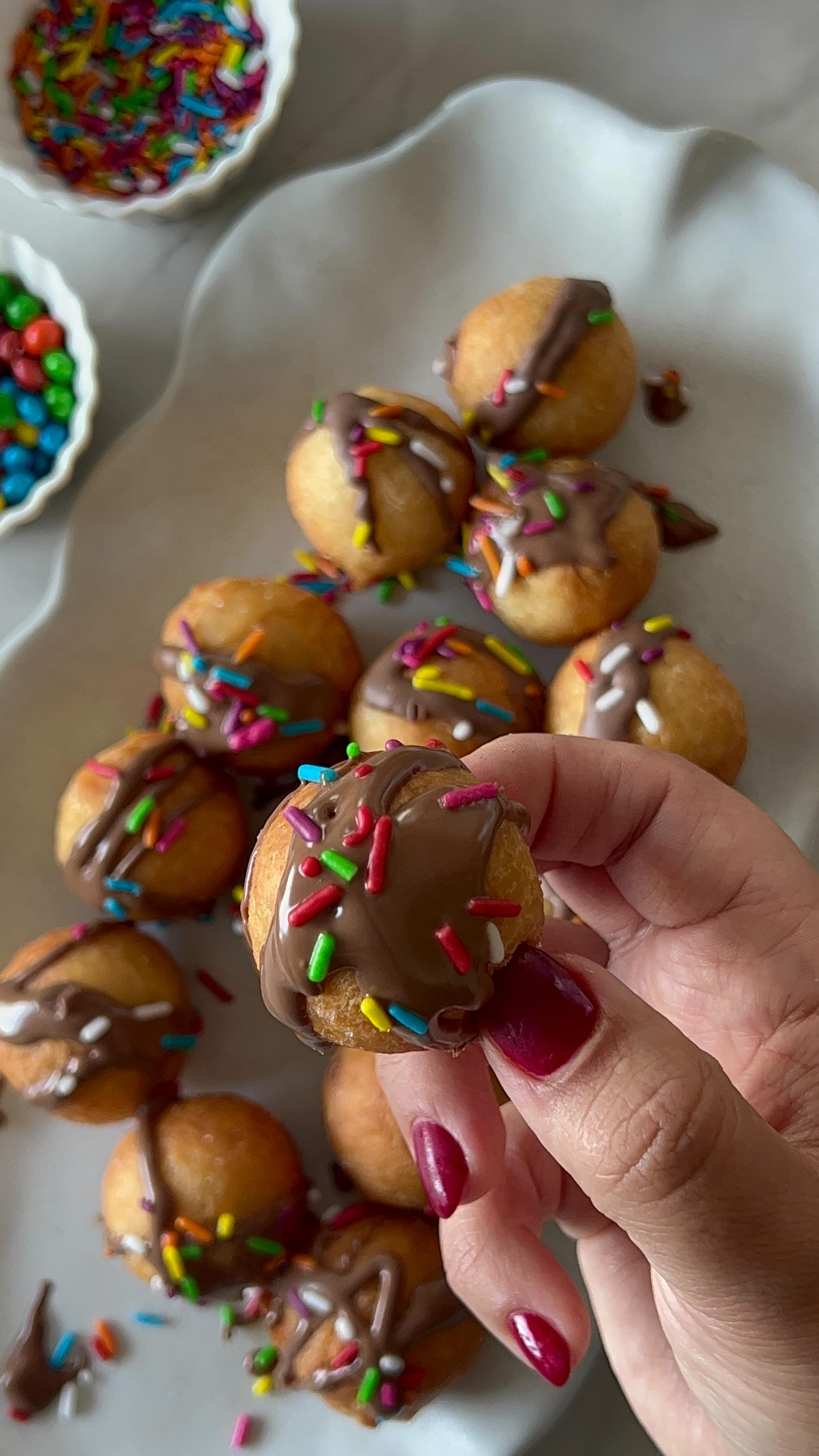 מיני סופגניות מהירות
טעימות בטירוף
קלות להכנה וכיף להכין ולקשט עם הילדים.
במקום שמן בבצק שמתי יוגורט יווני עשיר,שנותן רכות ולחות, עוזר לסופגנייה לתפוח יפה בטיגון, משפר את הטעם, מייצב את הבלילה, ומאפשר להכין סופגניות בלי שמרים ובלי זמן התפחה מהיר וטעים
לבצק:
260 גרם יוגורט יווני דנונה (2 גביעים)
50 גרם סוכר (¼ כוס)
קורט מלח
1 ביצה
250 גרם קמח (1 ו־¾ כוסות)
כפית וחצי אבקת אפייה
לציפוי
100 גרם שוקולד חלב/מריר מומס
כפית שמן
סוכריות צבעוניות / שברי עוגיות
שמן לטיגון עמוק
אופן הכנה
1. בקערה מערבבים יוגורט, ביצה, סוכר ומלח, ומאחדים בעזרת מטרפה.
2. מוסיפים קמח ואבקת אפייה, ומערבבים עד לקבלת תערובת אחידה.
3. מחממים בסיר שמן לטיגון על אש בינונית (170 מעלות). אם אין מדחום, מכניסים שיפוד ובודקים שיוצאות סביבו בועות עדינות.
4. משמנים מעט את הידיים, ומגלגלים מהבצק כדורים קטנים.
5. מכניסים לשמן הסופגניות צפות למעלה. מטגנים כ־5 דקות, או עד שהן זהובות מכל הצדדים.
6. מוציאים לנייר סופג.
7. מזלפים מעל שוקולד מומס, ומפזרים סוכריות או שברי עוגיות.
8. אפשר גם לגלגל בסוכר או אבקת סוכר.
9. מגישים לצד ריבה שאוהבים.
בשיתוף דנונה