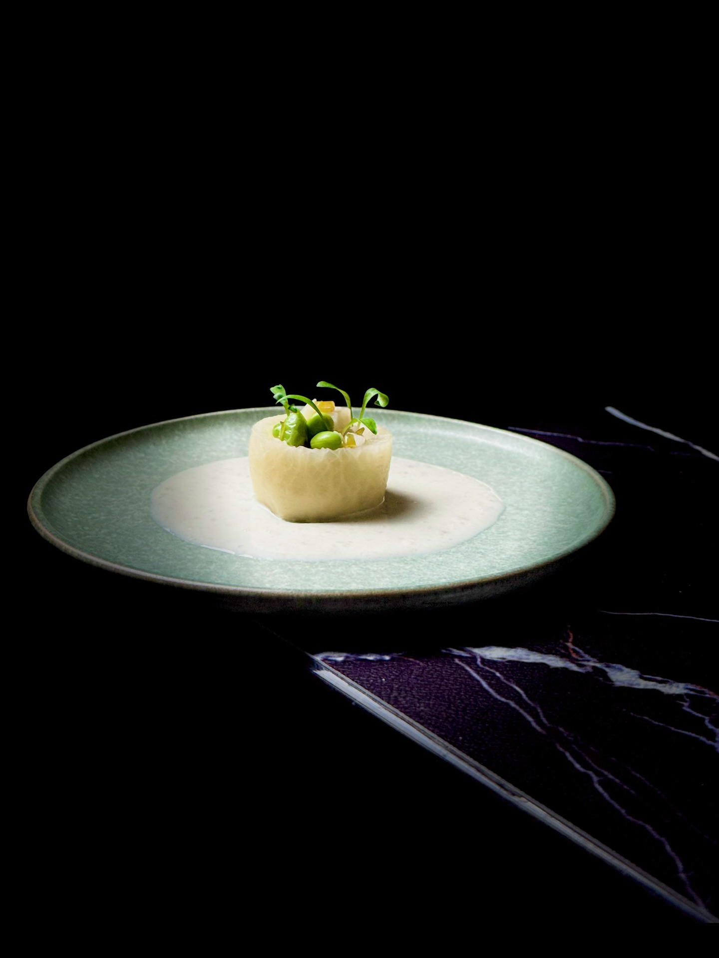 【Échos Croquants sous la Neige | 雪时脆语⋅冬藏三物】
Ce plat présente un radis blanc mariné, garni de dés de lotus, de edamame et de feuilles de moutarde fermentées. Sa texture acidulée et croquante évoque une bouffée de fraîcheur dans la profondeur de l’hiver ❄️🥢.
Autour des trois solstices et micro-saisons de Daxue, Dongzhi et Xiaohan, la tradition culinaire chinoise privilégie les légumes-racines, symboles de réserve et d’énergie enfouie 🌱🌨️. Le radis blanc, souvent surnommé le “ginseng du pauvre”, aide à la digestion, allège les repas riches et favorise la circulation du Qi 🌬️. Le rhizome de lotus, plus doux et farineux en hiver, nourrit le sang et apaise la sécheresse intérieure 🍂.
L’association du radis croquant, du lotus tendre et des parfums salins et végétaux crée un dialogue délicat avec l’hiver — une composition culinaire qui reflète le calme et la douceur des jours froids 🧘♂️🥗.
这道菜以腌制白萝卜为器,内填藕丁、毛豆与雪菜,酸脆清爽,像冬日里的一缕醒神之气 ❄️🥢。
在 24 节气中的大雪、冬至、小寒时节,人们讲究“冬令进补、以根入藏” 🌱。白萝卜被称为“小人参”,能顺气化痰、助消化、减积滞,为冬日厚味带来清爽的调和 🌬️。藕在入冬后变得粉糯甘甜,有补气养血、生津润燥之效 🍂。
腌萝卜的冷脆、藕丁的温润、雪菜的咸香与毛豆的甘甜共同串联起冬天“藏、静、暖”的节律,成为对冬令三节气的轻盈表达 🧘♀️🥗。
Reservation: www.bistrowu.com
#CuisineChinoise #Gastronomie #Hiver #Daxue #Dongzhi #Xiaohan #RadisBlanc #Lotus #SeasonalFood
#冬令进补 #大雪 #冬至 #小寒 #白萝卜 #莲藕 #时令料理 #中国味道 #aix #aixenprovence #aixmaville #aixenpce #aixenprovencetourism #aixenprovence❤️ #aixenprovencesortie #aixenprovenceweed🔥🍁❄️☘️ #aixoise #aixmarseille #aixcommerçants