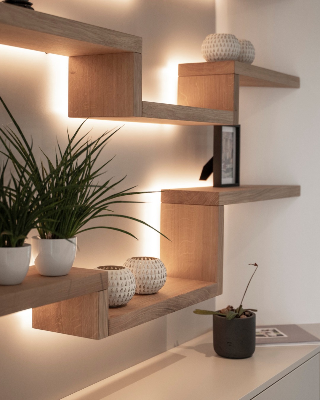 Ein Regal aus feinstem Massivholz – präzise gefertigt und mit warmem Licht hinterleuchtet. So entsteht eine elegante, zugleich heimelige Atmosphäre, die jedem Raum Charakter verleiht.