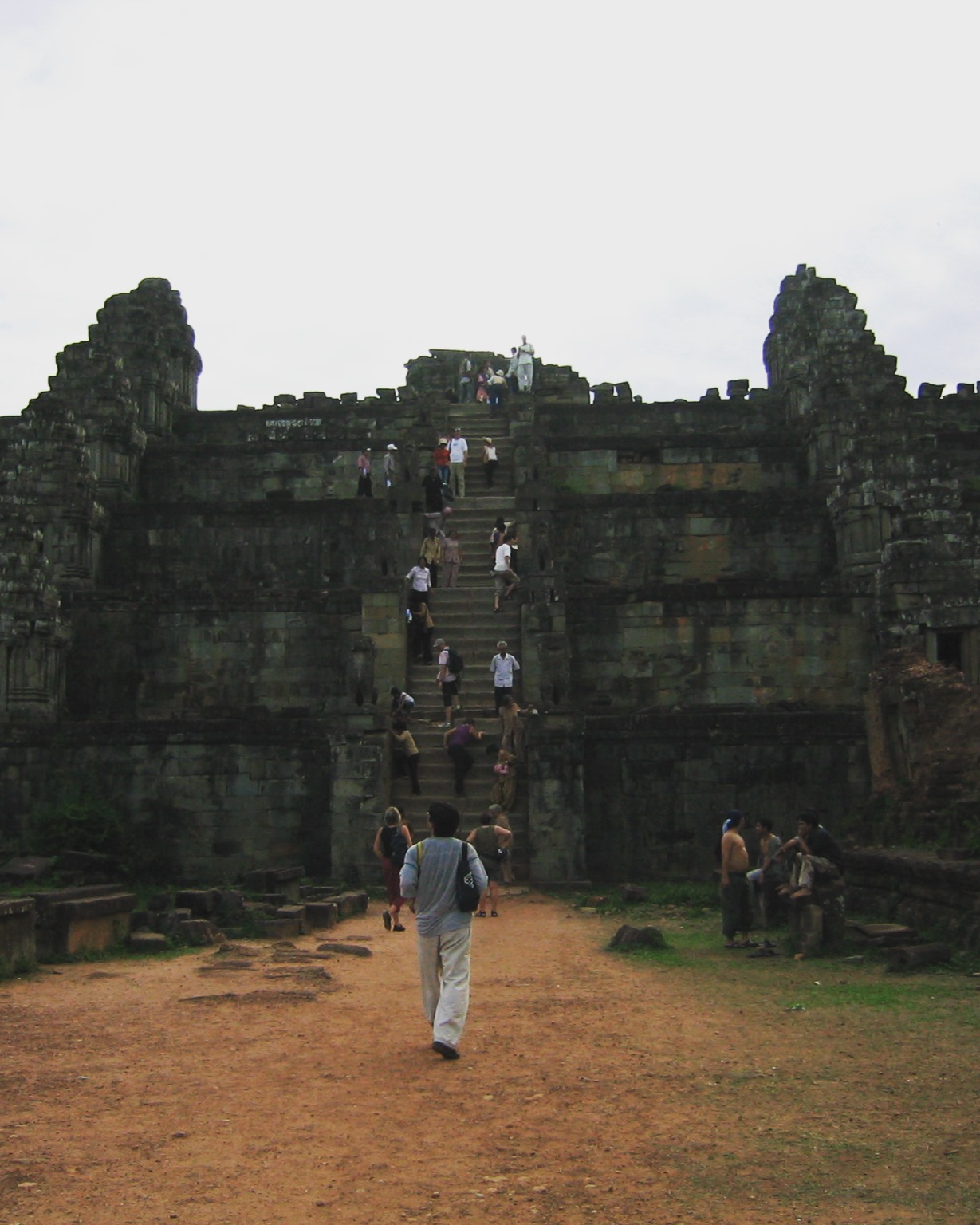 Passage from Travels in the Land of Hunger: A backpacker's earthbound journey from the East to the West 🌏📖
Tuesday, May 20, 2004
Leonardo and the other driver took us to Prasat Trapeang Ropou. Many tourists and backpackers gathered at this site to hike and climb Phnom Bakheng, a Hindu and Buddhist temple built in the 9th century, to view the sunset from its peak. We followed the crowd to a ruined stone staircase to ascend a hill covered in thick tropical vegetation. At the top of the stairs and across a flat open plain stood the impressive walled pyramid temple ruin of Phnom Bakheng, composed of five levels. We walked across the plain peppered with stone ruins to the nearly vertical sandstone staircase that led up the eastern side of the temple. Once we had climbed the stairs, Robert and I took in the beauty of the thick, green canopy of tropical trees that expanded to the grey horizon in all directions. Hidden within this verdure were the monuments of Angkor’s long and once-lost civilization.
We waited for the sun to set, knowing the cloudy evening would prevent the best experience. Regardless, waiting at the top of this temple, crowned by five towers with so many people from around the world, was fascinating.
#TravelsInTheLandOfHunger #travelmemoir #memoirwriting #indieauthor #bookexcerpt #backpacking #backpackinglife #solotravelers #travelphotography #cambodia #cambodiatravel #adventuretravel #traveldiaries #siemreap #phnombakheng