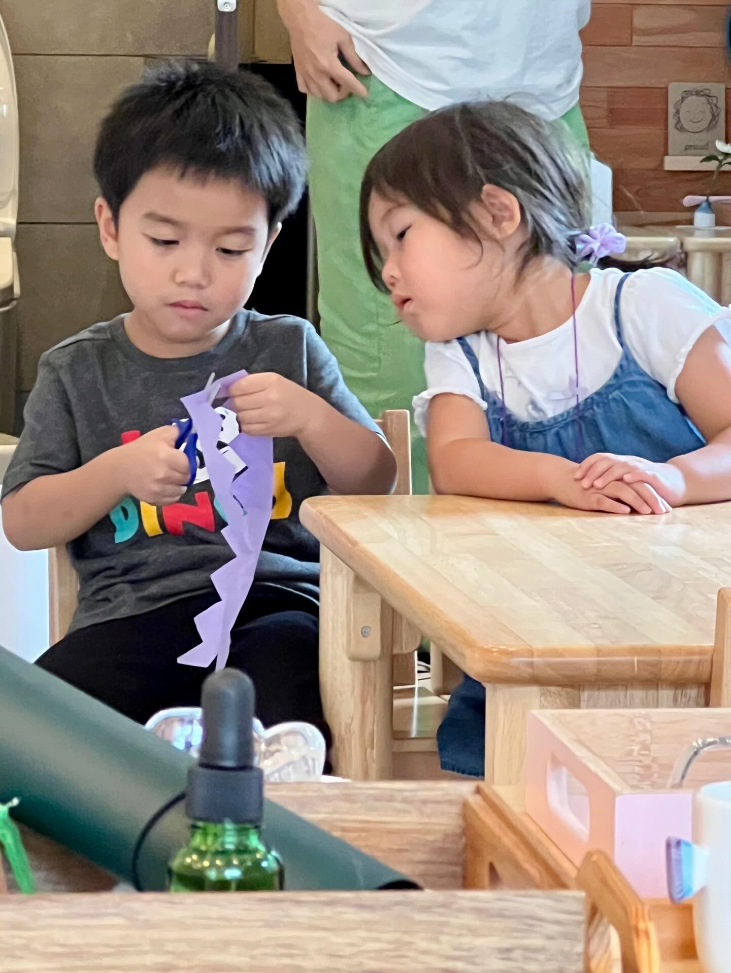 Offering to tie someone’s apron strings or helping a friend cut a crown, Montessori children learn service through everyday actions.
Ask your child, “How can we help someone today?” and explore their idea together.