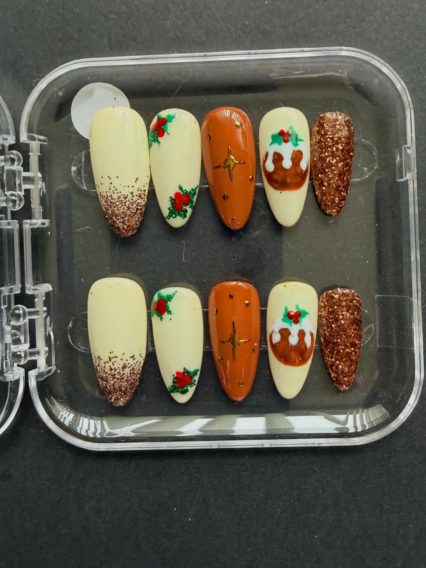 Hand painted brown and cream Christmas press on nails with Christmas pudding and holly nail art #nailsnailsnails #christmasnails #nailart #naildesign #christmas #nailartist #handpaintednails