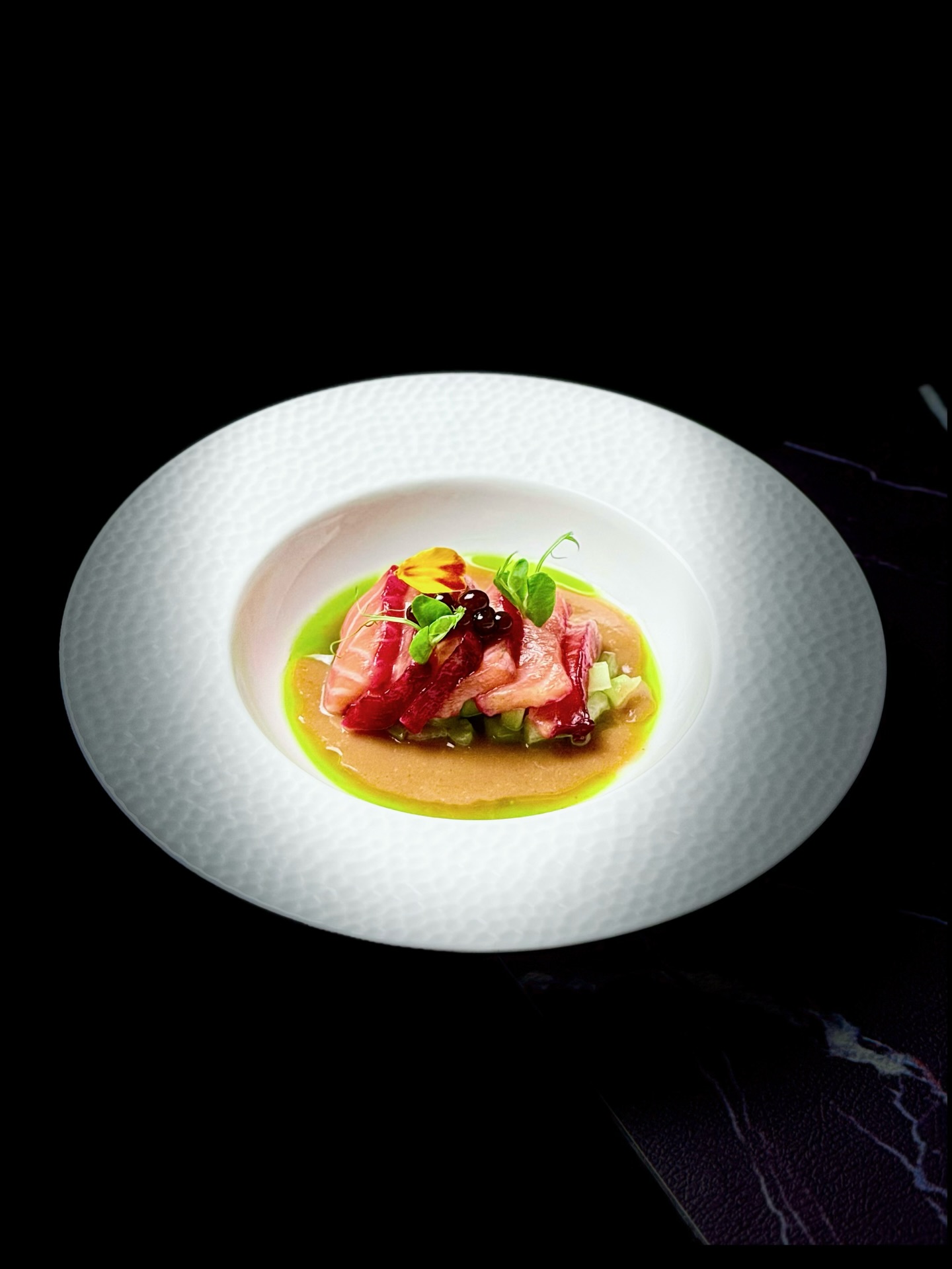 【Rouges d‘Hiver, Murmure Acidulé | 寒林酸影⋅冬至红语】
Ce plat met en scène un saumon tendre, accompagné d’une sauce tamarillo-aubépine (shān zhā), d’huile de menthe et de vinaigre caviar 🐟✨. Les nuances de rose et de rouge rappellent la transition des trois micro-saisons — Dàxué, Dongzhi et Xiăohán — du calme à la froideur, puis au repos profond ❄️🌅.
Dans la tradition chinoise, l’aubépine est un ingrédient hivernal précieux : après Dàxue, les repas s’enrichissent ; autour de Dongzhi, le corps emmagasine l’énergie ; et pendant Xiaohan, le métabolisme ralentit 🌬️🌨️. L’aubépine équilibre ces excès grâce à sa vivacité acidulée 🍒✨.
Bienfaits traditionnels de l’aubépine :
• Favorise la digestion et allège les plats hivernaux 🍽️💨
• Stimule la circulation sanguine, soulageant la stagnation due au froid ❤️🔥
• Apporte une acidité revivifiante, éveillant l’appétit et les sens 🌟
Ici, son acidité diffuse équilibre la richesse du saumon, tandis que l’huile de menthe ajoute une fraîcheur cristalline et le vinaigre caviar une touche vive — comme un éclat de lumière au cœur du solstice d’hiver 🌌✨.
Ce plat exprime l’harmonie hivernale chinoise :
dissiper la lourdeur, réchauffer le cœur, éclairer le froid ❤️❄️💡
这道菜以柔嫩的三文鱼为主体,配以番茄山楂酱、薄荷油与醋鱼籽 🐟✨。粉红与深红在冬日的白盘上交叠,如大雪、冬至、小寒三节气的色彩渐变——从静,到寒,到藏 ❄️🌅。
在中国冬季饮食中,山楂是古老而智慧的食材:大雪后进补渐重;冬至时人体蓄能;小寒时气温骤降、运化变慢 🌨️🌬️。山楂以酸化滞、暖气血、醒味觉的力量,成为冬令温柔而强效的调和者 🍒✨。
山楂的传统功效:
• 助消化、化积滞,减轻厚味负担 🍽️💨
• 活血、舒缓胸闷,改善寒致不畅 ❤️🔥
• 酸甜生津、醒胃提神,唤醒冬日沉潜的气机 🌟
山楂的酸果力平衡三文鱼的丰润;薄荷油带来一缕冬日清气;醋鱼籽的亮酸如冬至短暂微光,冷冽却明亮 ❄️✨。
整道料理宛如冬令三节的缩影:
以酸驱滞,以红生暖,以鲜化寒 ❤️❄️💠
Reservation: www.bistrowu.com
#CuisineChinoise #Gastronomie #Saumon #Hiver #Daxue #Dongzhi #Xiaohan #Hawthorn #SeasonalFood
#冬令进补 #大雪 #冬至 #小寒 #三文鱼 #山楂 #时令料理 #中国味道 #aix #aixenprovence #aixmaville #aixenpce #aixenprovencetourism #aixenprovence❤️ #aixenprovencesortie #aixenprovenceweed🔥🍁❄️☘️ #aixoise