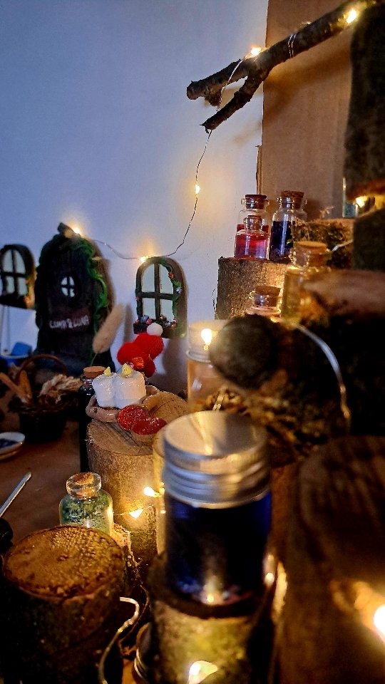 Hier lebt unser Wichtel, gemeinsam mit seiner Freundin der Waldfee, sie leben hier das ganze Jahr, im Sommer haben sie auch einen Unterschlupf im Garten, in dem Beet in der großen Zinkwanne.
Andere Wichtel machen ganz schön viel Blödsinn, einige stressen die Mütter ganz schön, andere gehen völlig darin auf die Wichtelaktionen zu begleiten – und das ist total schön, ich habe auch schon gehört das Mütter sich dagegen sträuben, weil sie den Aufwand scheuen und das kann ich gut verstehen,
ich habe auch keine Lust und Energie fast täglich Wichtelstreiche vorzubereiten – darum sind unsere kleinen Mitbewohner anders, sie schreiben ganz selten mal Briefe, ab und zu bringen sie mal ein Geschenk (Bücher für die Adventszeit, Streusel für die Kekse, oder sowas, was die Kinder eh kriegen sollten) und Streiche spielen sie so gut wie nie – nur wenn ich eine richtig gute Idee habe und dann einen Hyperfokus entwickel der sich auf das ganze Haus ausbreiten kann.
Unser Wichtel-Zuhause wird von den Kindern mitgestaltet, alles was dort steht haben die Kinder allein oder wir gemeinsam (in der Natur) gesammelt, gebaut, gebastelt und aufgebaut. Tür und Fenster sind das ganze Jahr dort, ab November fangen wir an den Rest aufzubauen und im Frühjahr wandert vieles in den Wichtel-Karton und ein paar wenige Dinge ziehen in den Garten wo aus Baumrinde eine Hütte gebaut wurde (die Idee hatte meine Tochter ganz alleine).
Das Regalbrett ist an unserem Küchentisch, sie sind also immer dabei und manchmal erzählen die Kinder den beiden Dinge oder Fragen etwas, dann kommt meistens eine Antwort auf einem normalen Notizzettel (kein Wichtelpapier) oder die Kinder reimen sich die mögliche Antwort selbst zusammen und lassen den Wichtel und die Waldfee damit zum Leben erwachen.
Warum ich das erzähle? Weil ich dich inspirieren möchte, wenn du mit dem Wichtel-Stress haderst aber ihr trotzdem den Zauber im Haus haben wollt. Es braucht keine täglichen Briefe und Streiche, es braucht nicht mal viel Equipment – es braucht nur eine Tür und gemeinsame Zeit mit den Kindern, die wir in der Regel ja sowieso haben und mit basteln füllen können.
Es braucht nur Phantasie* und schon entsteht Magie.