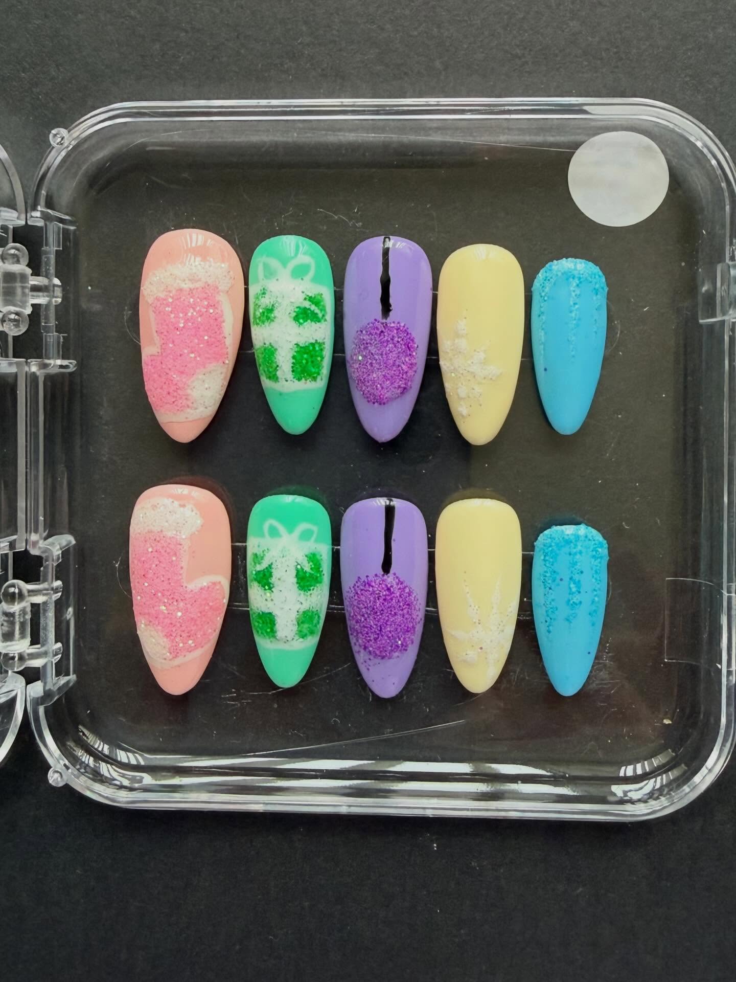 Hand painted pastel coloured Christmas press on nails with Christmas nail art and glitter #nailsnailsnails #christmasnails #handpaintednails #nailart #christmas #nailartist #naildesign