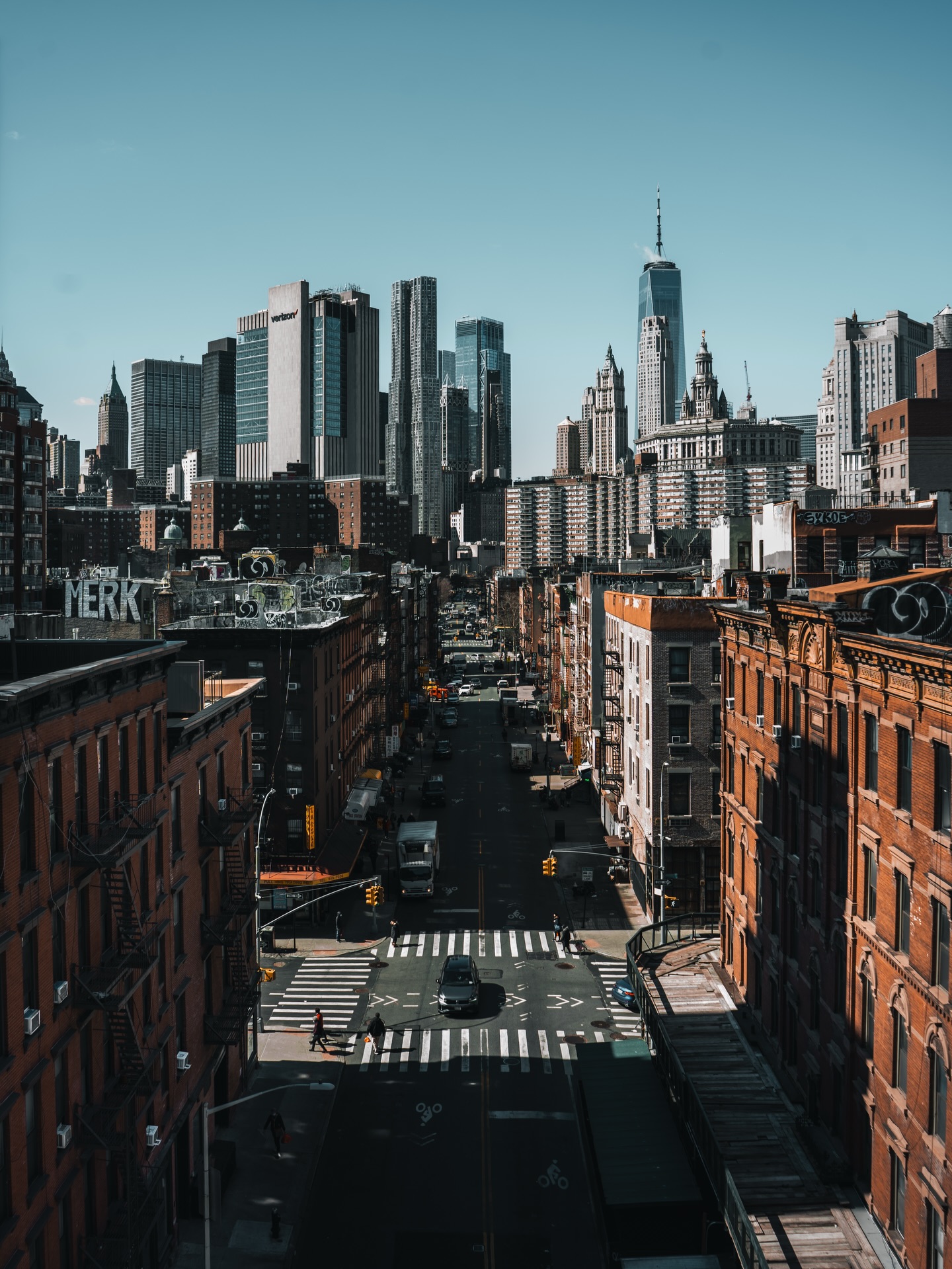 Der Verkehr drückt, Menschen schieben sich über die Kreuzungen, irgendwo zischt der Asphalt und keiner zuckt nur ein bisschen. Alles bewegt sich, alles hat Tempo, aber niemand wirkt überrascht. Es ist dieser Grundlärm, der Dich nach ein paar Minuten nicht mehr nervt, sondern wach hält.
Zwischen Chinatown, der Bridge und den Blocks dazwischen zeigt die Stadt ihr wahres Gesicht. Kein Glitzer, kein Filter, nur Schilder, rostige Feuerleitern, kaputte Fassaden und Ladentüren, die schon tausendmal geöffnet wurden. Genau deswegen hat New York so viel Charakter. Jeder Block erzählt eine Geschichte, aber keiner macht es Dir leicht. Du musst hinsehen, sonst rauscht alles einfach an Dir vorbei.
Die Skyline wirkt aus der Ferne wie eine Mauer. Klare Kanten, kaltes Glas, Beton, der keinen Platz für Sentimentalität lässt. Aber genau das passt. New York ist direkt. Hart. Laut. Manchmal völlig egal. Und trotzdem zieht sie Dich rein. Nicht, weil die Stadt schön sein will, sondern weil sie genau das Gegenteil davon ist. Echt. Unverstellt. Unbeeindruckt von Dir, mir oder irgendwem.
Vielleicht ist es genau das, was hängen bleibt. Dieses Gefühl, dass Du in einem riesigen Organismus stehst, der Dich nicht braucht, Dir aber trotzdem ständig etwas zumutet. Schritt für Schritt, Block für Block. Kein Glamour, nur die Straßenluft und ein Tempo, an das man sich anpassen muss.
#newyork #nycstreetphotography #streetphotography #manhattan #chinatownnyc #urbanphotography #cityvibes #travelphotography #nycstreets #bigapple #fokusfernweh