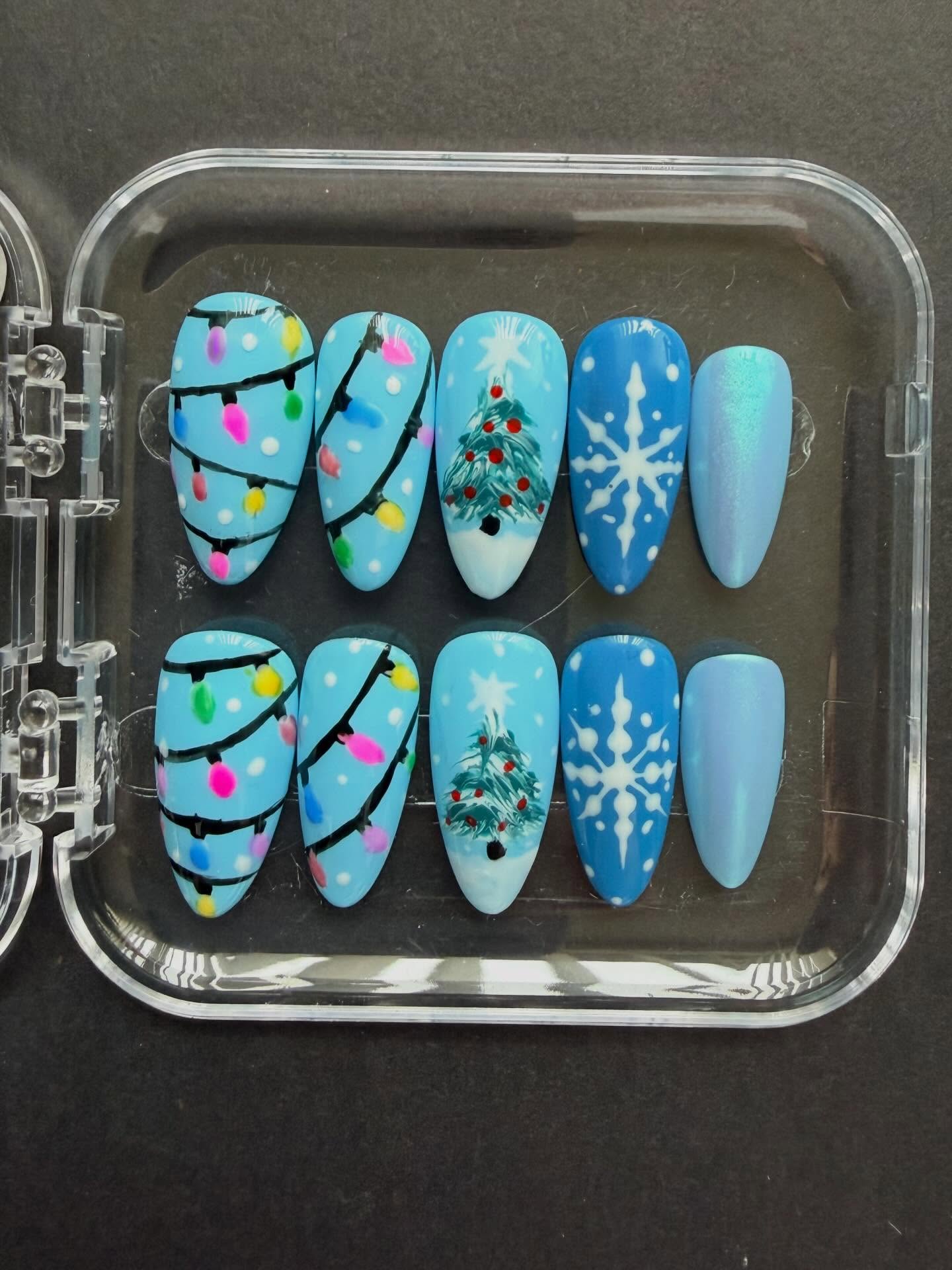 Hand painted blue Christmas press on nails with Christmas lights and Christmas tree nail art #nailsnailsnails #nails #christmasnails #handpaintednails #nailart #christmas ##naildesign