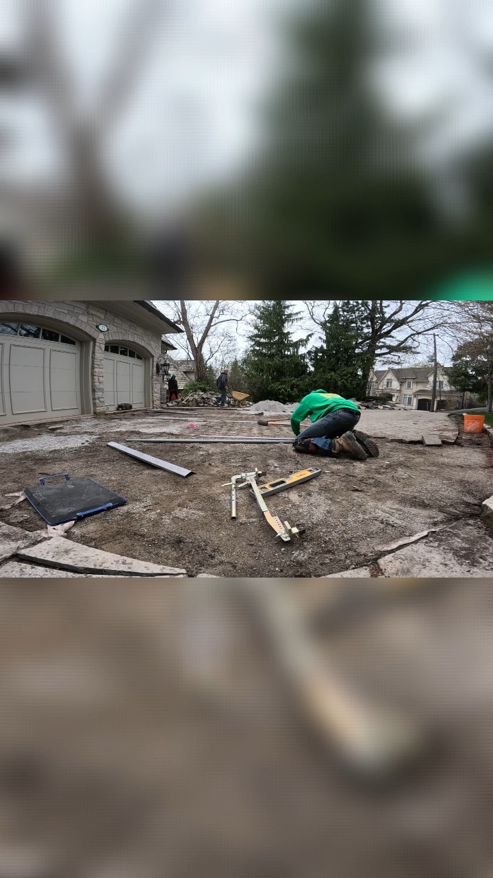 Marlon releveling a driveway. The pipes are used for getting the grade β