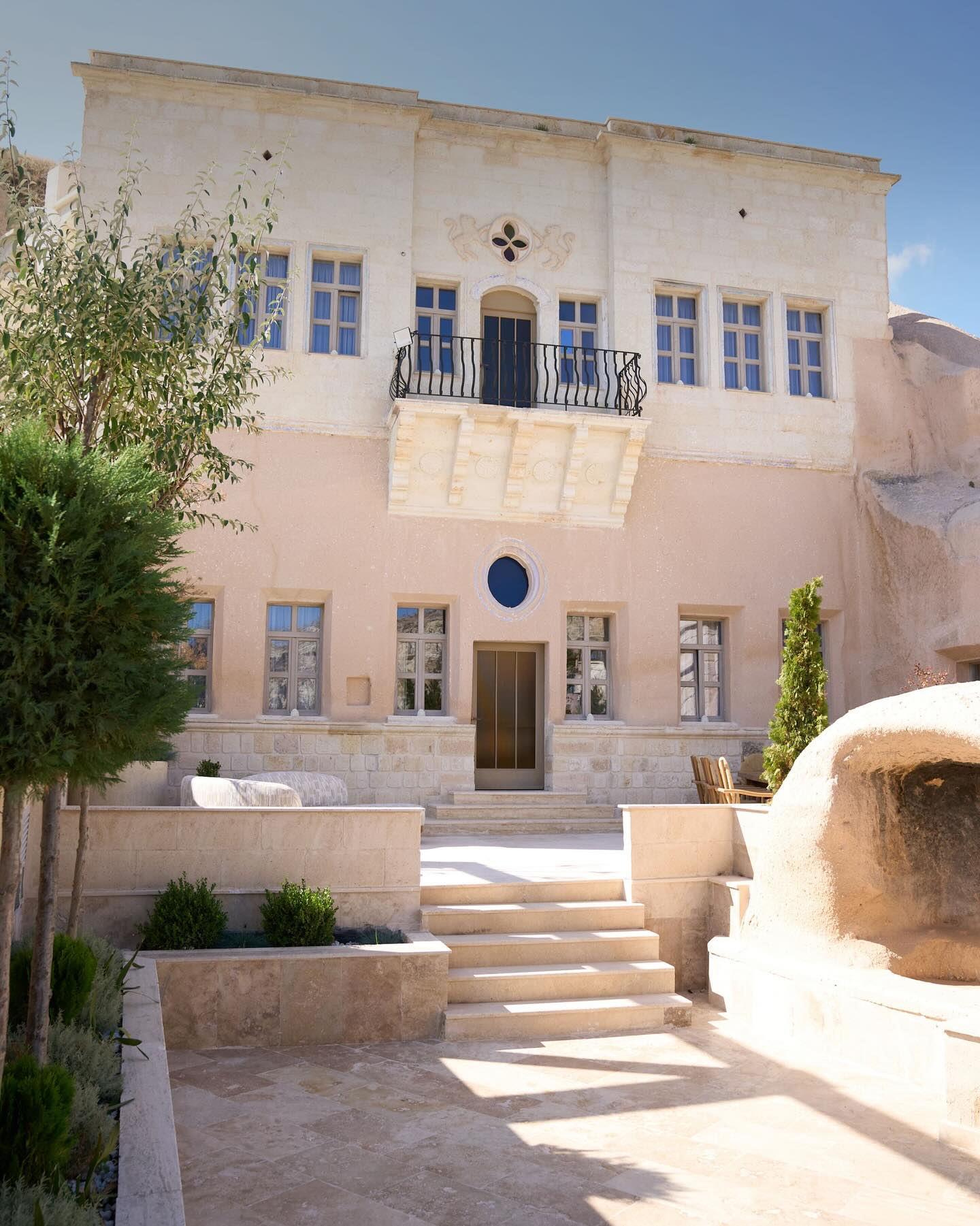 Priest’s Mansion, a secluded private residence within Avantgarde Refined, offers an unparalleled atmosphere for guests seeking profound intimacy and space. Eminently suited for large families, extensive groups, and intimate small gatherings alike, this dedicated residence provides generous sleeping quarters and the unmatched advantage of a private courtyard.
More than a place to stay, it is part of Ürgüp’s living heritage. The mansion once belonged to the priest who served at the nearby 19th-century Aziz Georgios Church, and its cave rooms still carry the quiet traces of the town’s intertwined Greek and Anatolian past. Staying here means stepping into a setting shaped by centuries of craftsmanship, carved into the soft volcanic stone that defines the region.
Guests enjoying their time together here will forge a meaningful connection with Cappadocia’s architectural texture and cultural depth. Dedicated rooms and direct access to a secluded garden ensure your group finds its desired, undisturbed harmony throughout the stay.
Get in touch for booking inquiries.
#avantgarderefined #cappadocia