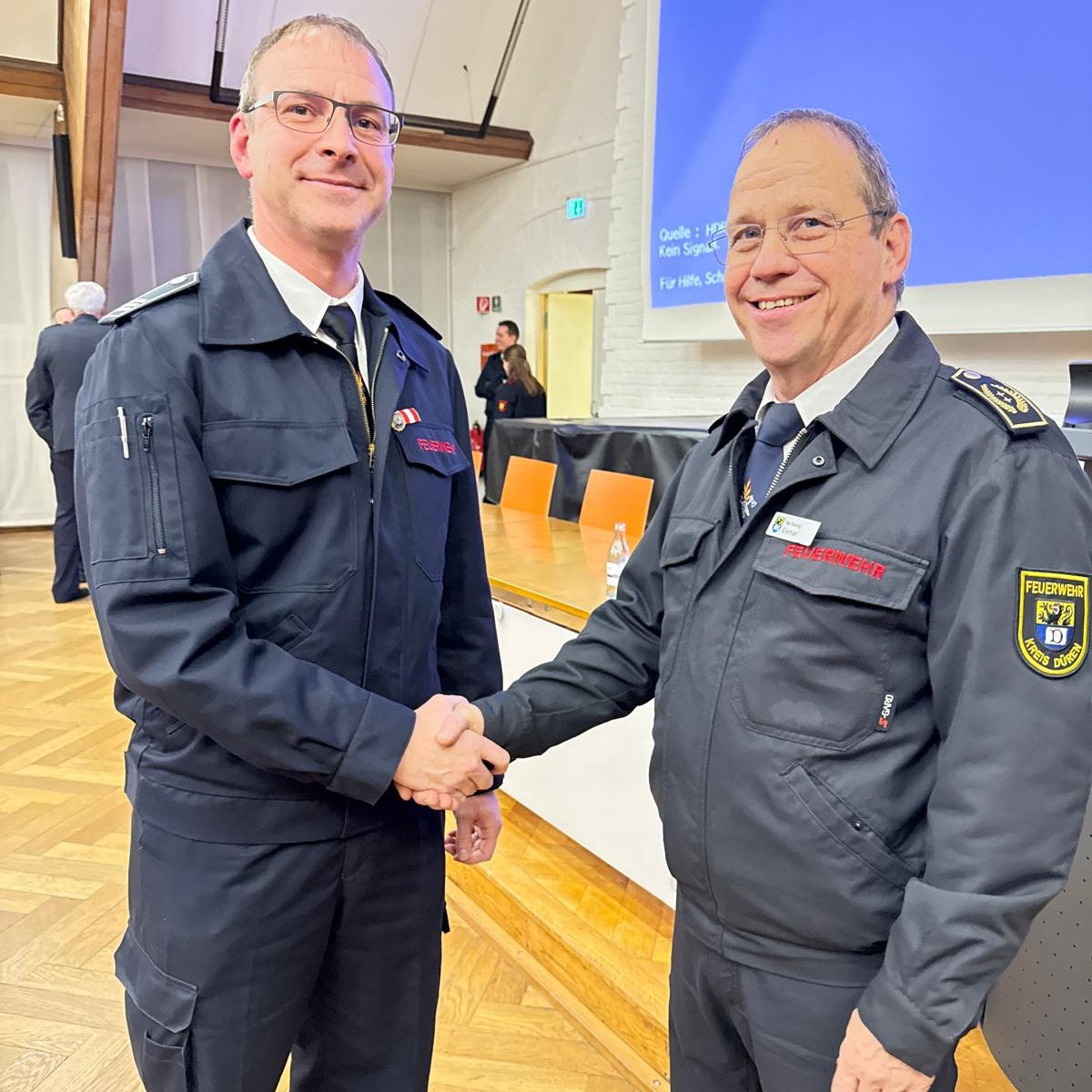 🔥 Verbandstag des Kreisfeuerverbandes Düren
- Marco Pütz folgt Karlheinz Eismar als erster Vorsitzender des Verbandes🔥
Am vergangenen Donnerstag fand in der Aula der Landwirtschaftsschule der turnusmäßige, alle drei Jahre stattfindende Verbandstag des Kreisfeuerverbandes Düren statt.
Dabei wurde auch der Vorstand neu gewählt.
Die Delegierten aller Feuerwehren im Kreis Düren wählten dabei Marco Pütz (Feuerwehr Nideggen) zum neuen 1. Vorsitzenden.
Er übernimmt das Amt von Karlheinz Eismar.
Karl-Heinz Eismar bleibt dem Vorstand weiterhin erhalten und wird künftig als einer der beiden stellvertretenden Vorsitzenden gemeinsam mit Wilfried Thelen (LdF Feuerwehr Aldenhoven) tätig sein.
🎉 Wir gratulieren Marco Pütz herzlich zu seinem neuen Amt!
- und bedanken uns bei Karl-Heinz Eismar für sein langjähriges Engagement.
Ein weiterer Bericht zur Verbandstagung folgt! (pb)
