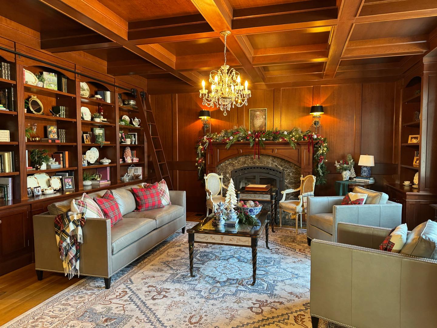 We are so blessed to have a formal library in our home, when I first saw the real estate listing for this house it’s the room that took my breath away! I still love this space however I have learned that these darker, formal spaces can be somewhat challenging to decorate. We have a large window in this space yet the dark wood panelling and wood coffered ceiling suck a lot of light out of this space. Both my husband and I didn’t want the room to feel like a “men’s only club”, we want it to be a space everyone feels welcome to come curl up with a warm cup of tea or a glass of wine, and simply visit. There is no TV, only books and the people you are blessed to be with.
For the holidays, in years past, I went all out in this room. Heavily adorned mantle, large Christmas tree, golds, blush and pinks to lighten the space and bring some female energy into a somewhat masculine space by nature. However, this year I did the exact opposite and I’m not sure I’ll be going back to a big grand statement piece anytime soon.
The more restrained tones of the traditional look I’ve used this year are, in my opinion, in perfect balance with the room. I admit, I miss a larger tree in here and next year will be adding that into the space but I do love the table tree, dried hydrangeas and chocolate brown deer I have used in it’s place this year.
This room took no new decor aside from the little houses adorning the table tree. I have owned tartan cushions for many years, they are simply a look I have long loved. In fact, the cushions with the tartan ribbon bows I remember purchasing them when I didn’t really have the money for fancy cushions but I did it anyway, I had to have them. They have survived my girls being little and 6 dogs, they were a solid purchase. ❤️
Much of this rooms decor holds memories for me, the blue and white china on the coffee table my mom bought me many years ago as a Christmas present. I love how this room has been curated with moments that bring back memories because that is what Christmas is to me. Being with the people I love and making new memories.
#christmas #christmasdecor #librarydecor #library #christmasseason