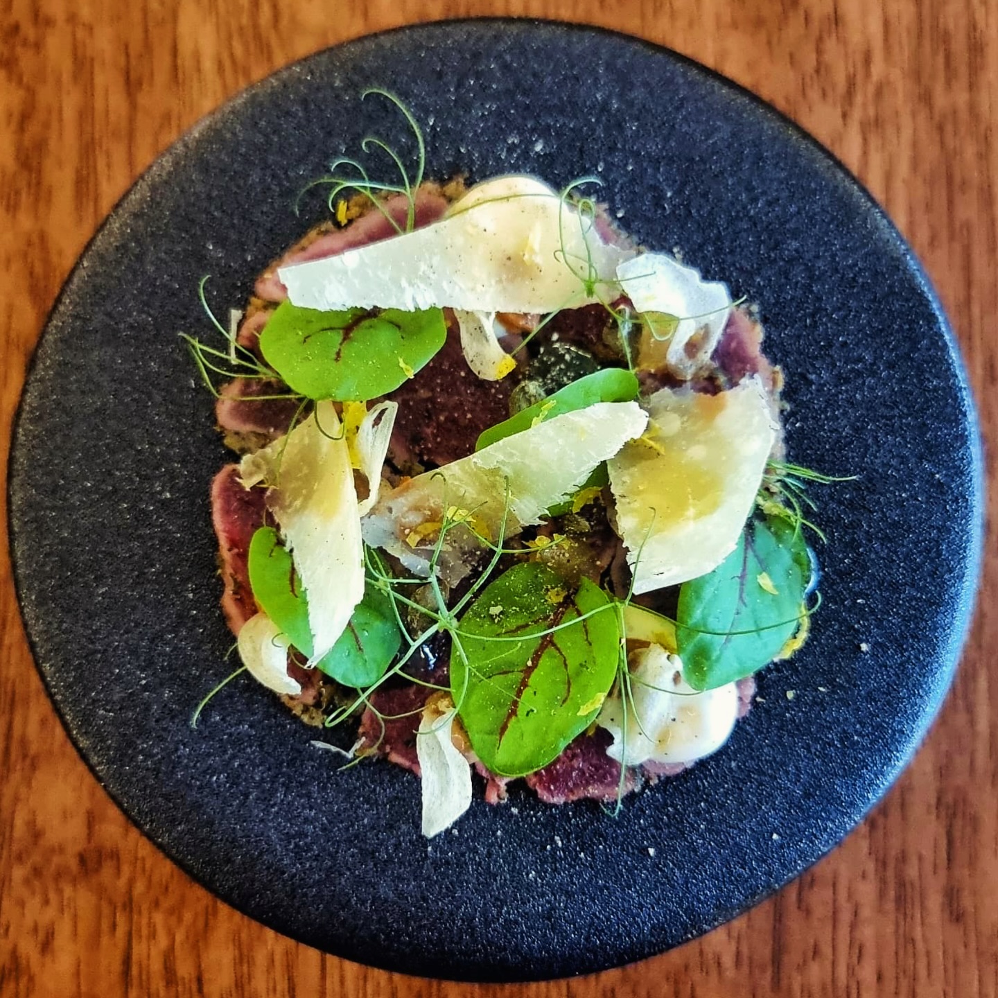 In an ancient ritual dating back to the fourth century and the first Christian emperor, Constantine, a tribute of the first-born male and female lambs of the year were crowned, one with a white crown symbolising purity, and the other red symbolising martyrdom, and blessed at the imperial basilica of Sant’Agnese Fuori le Mura and taken in procession to the Pope at the Lateran Basilica of St. John.
More than one and a half millennia later this tradition continues till today on the 21 January feast of St Agnes every year.
Celebrating the winter feast of lambs, our INVERNO winter Chef’s Table presents this suckling lamb carpaccio crowned with sage, rosemary, mint, harissa, anchovy emulsion, crisped capers and garlic, tuscan monocultivar extra virgin olive oil, shaved parmigiano reggiano, limoncello and mint gelées, horseradish aioli, and lemon zest; a tribute to tradition and a celebration of vibrant flavours in the bleak midwinter.