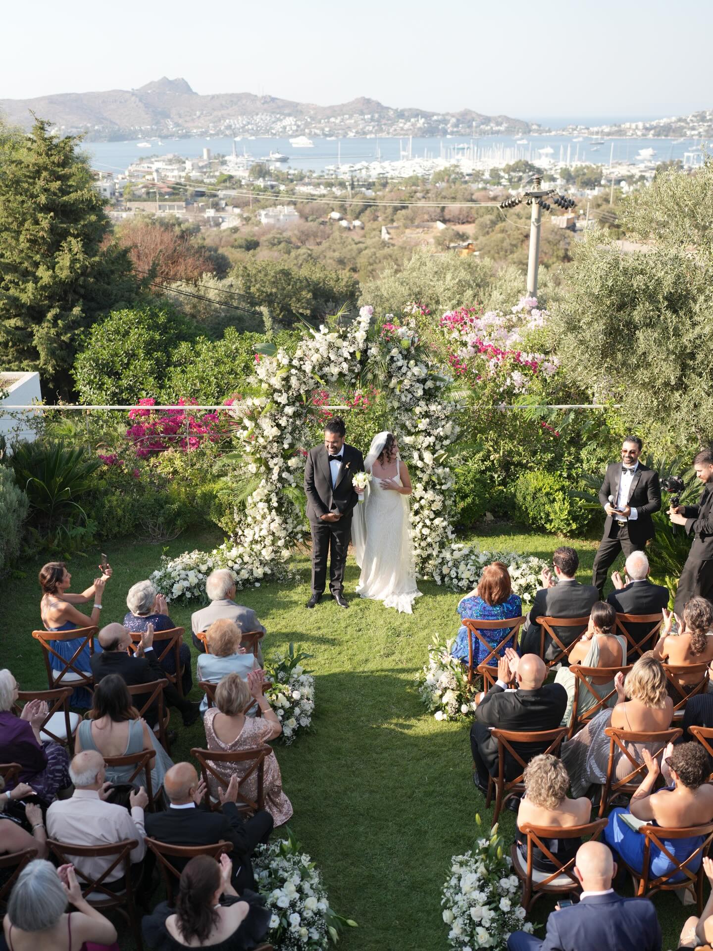 Dela & Roozbeh — two beautiful souls who brought their love to life in Bodrum, surrounded by their closest ones.
An elegant, minimalist design with all-white florals never fails to impress. The arch, adorned with lush tropical leaves, framed our couple with grace and serenity — a timeless look for a timeless love.
We were so honored to be part of this special day. Wishing you both a lifetime of joy, laughter, and endless love.
We love you guys!
#DelaAndRoozbeh #KaremEvents #BodrumWeddings #MinimalistElegance #AllWhiteWedding #TropicalArch #DestinationLove #TimelessRomance